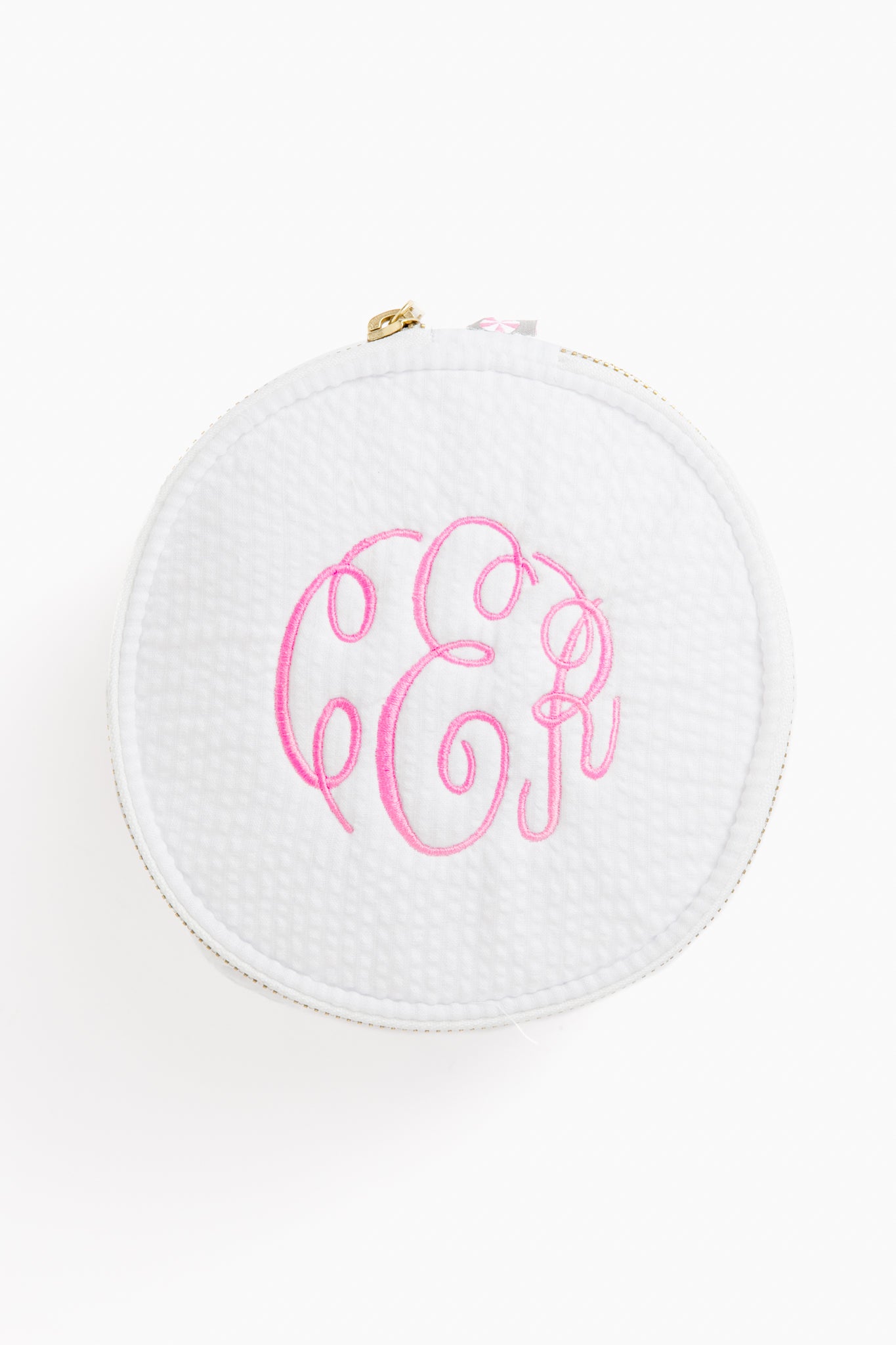 Caton's Wharf round white zippered button bag with a textured surface and pink monogram initials embroidered on top.