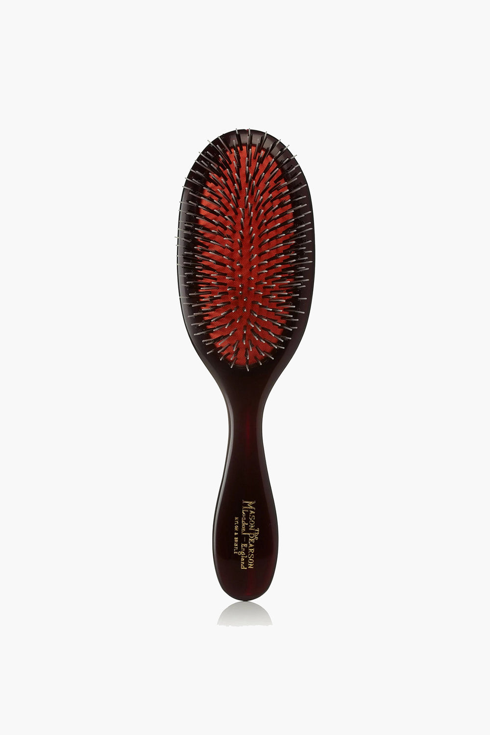 A Mason Pearson hair grooming tool featuring a dark handle, a red cushion, and a mix of black and silver bristles.