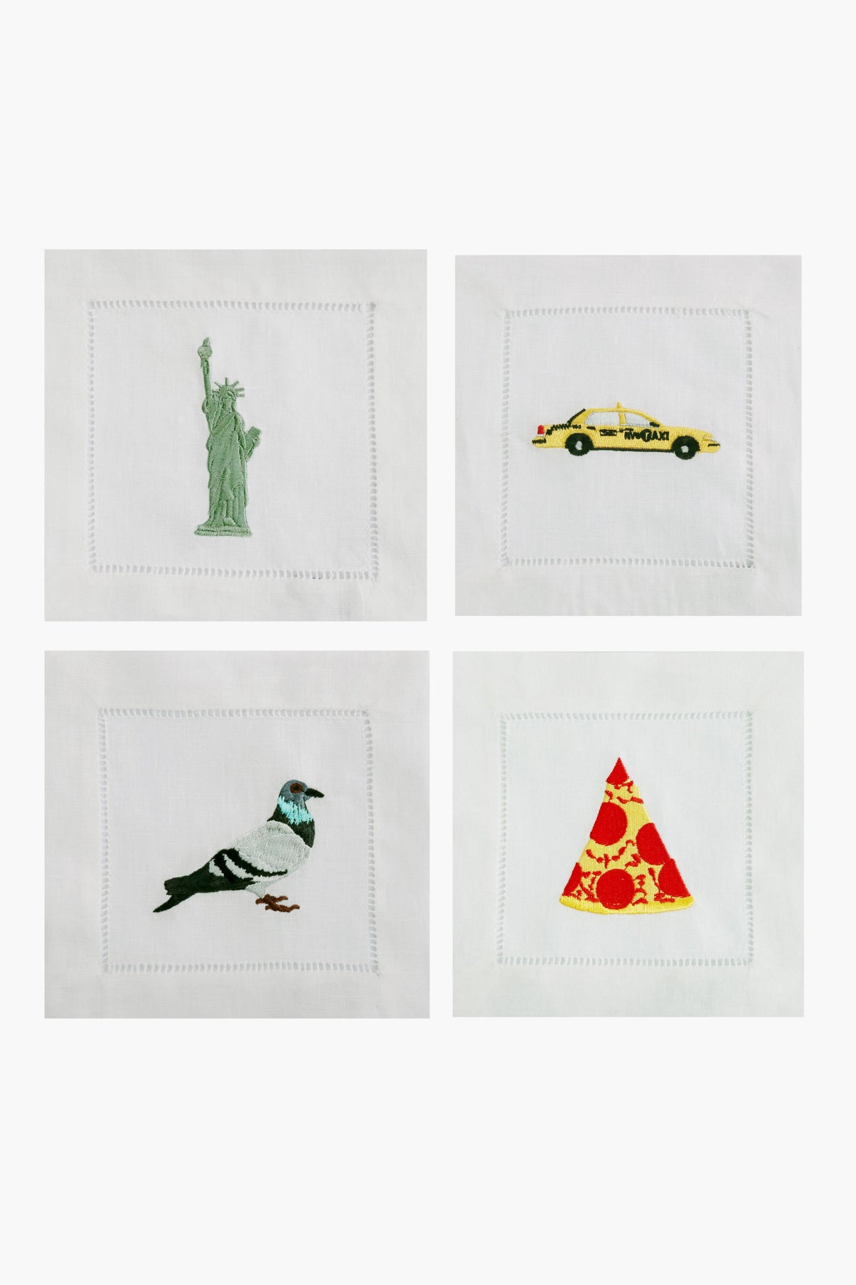 The Chefanie embroidered napkin set includes four white linen cocktail napkins, each adorned with iconic New York motifs: the Statue of Liberty, a yellow taxi, a pigeon, and a slice of pepperoni pizza.