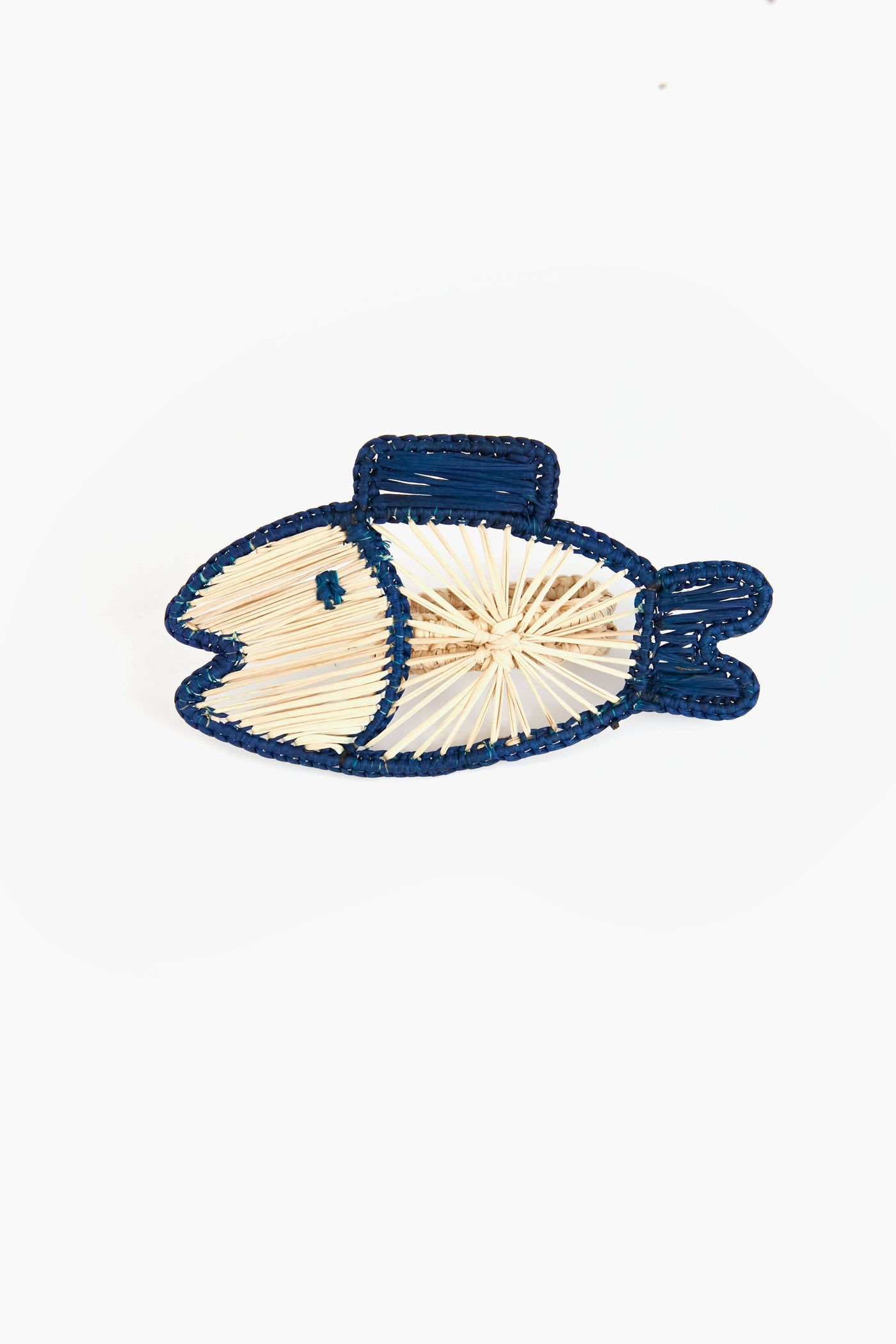 A fish shape outlined with blue thread and a beige crisscross body—this Coro Cora artisan piece showcases the distinct beauty of Colombian Iraca palm homeware accessories.