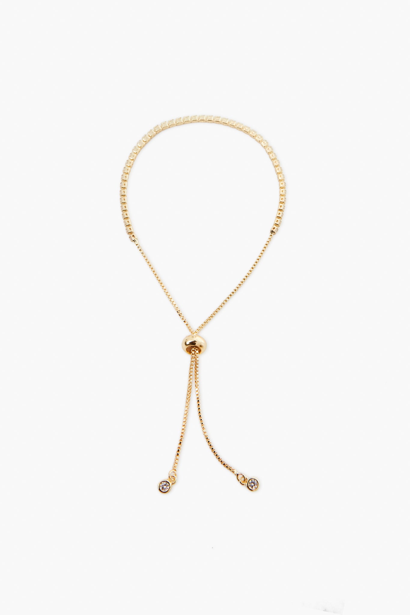 A gold adjustable necklace from Petit Moments, a woman-owned Los Angeles brand, features a round sliding clasp and two dangling ends, each with a small circular charm.