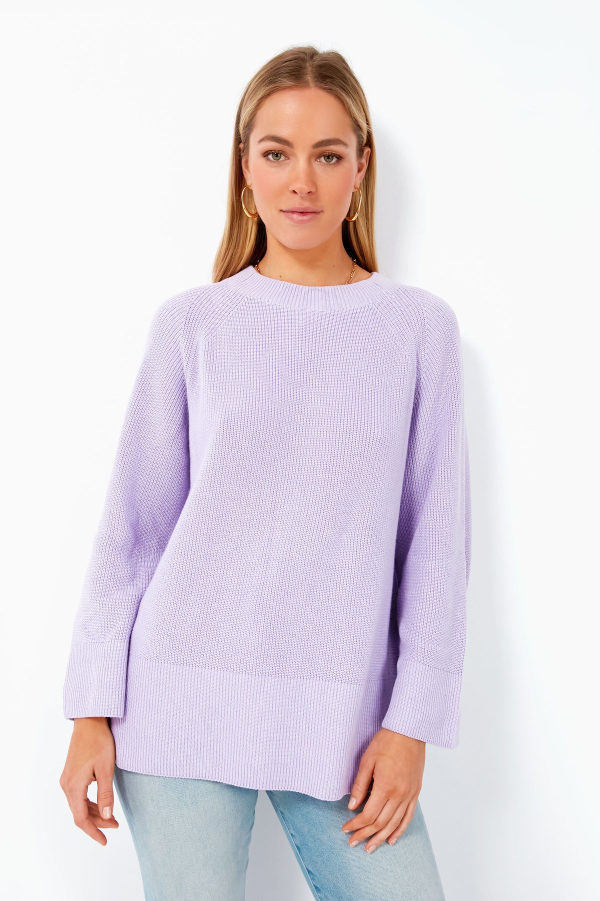 A woman models a loose pastel Barbour sweater and light blue jeans, highlighting the cozy look of the Barbour Iris Barrhead Knit.