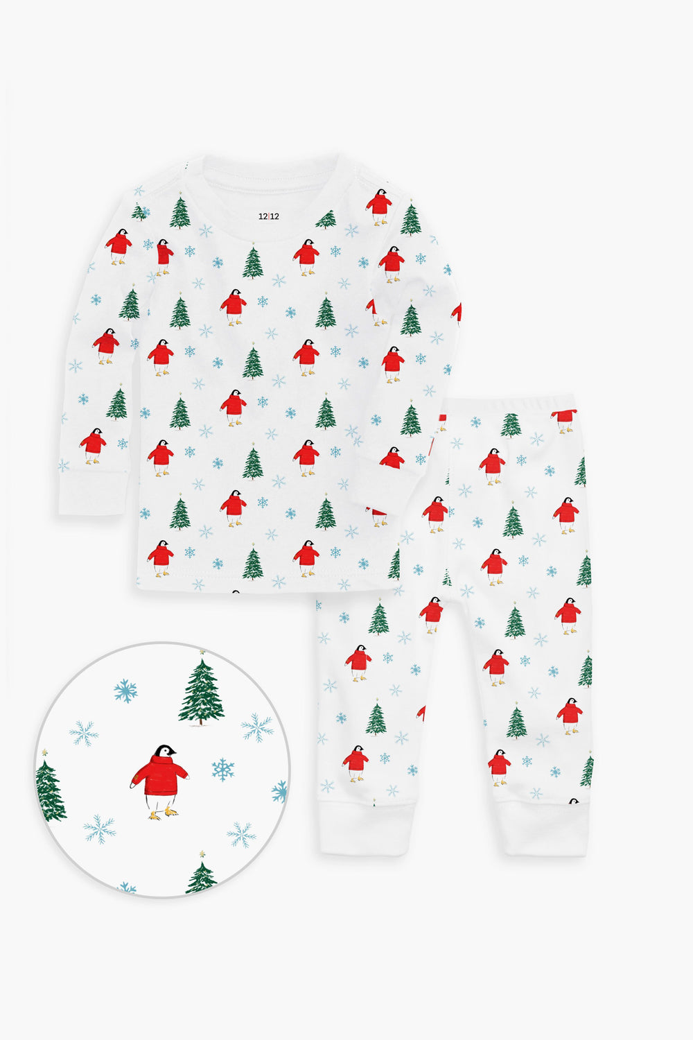 12|12 children’s white cotton pajama set with a festive print of red birds, green trees, and blue snowflakes. OEKO-TEX certified for toddler comfort; close-up highlights the charming details.