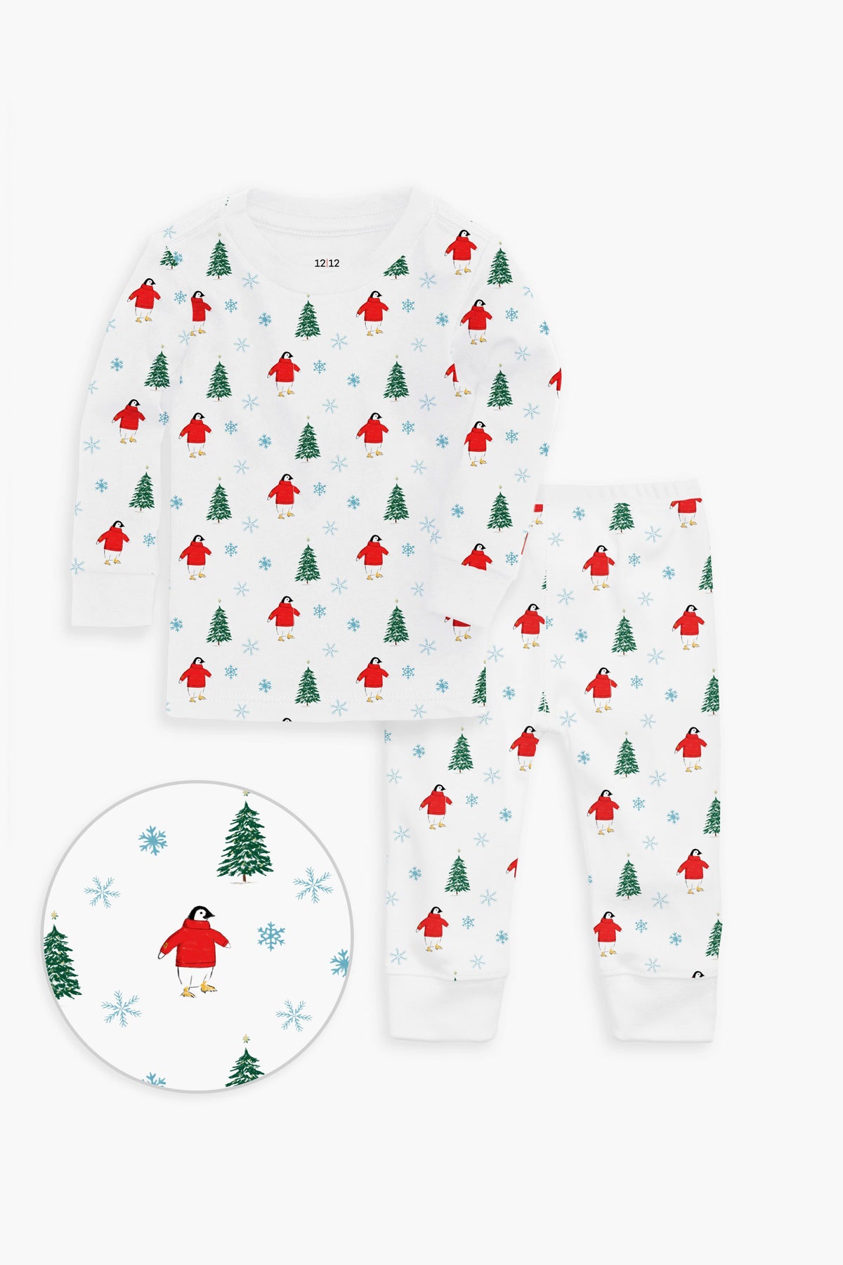 12|12 children’s white cotton pajama set with a festive print of red birds, green trees, and blue snowflakes. OEKO-TEX certified for toddler comfort; close-up highlights the charming details.