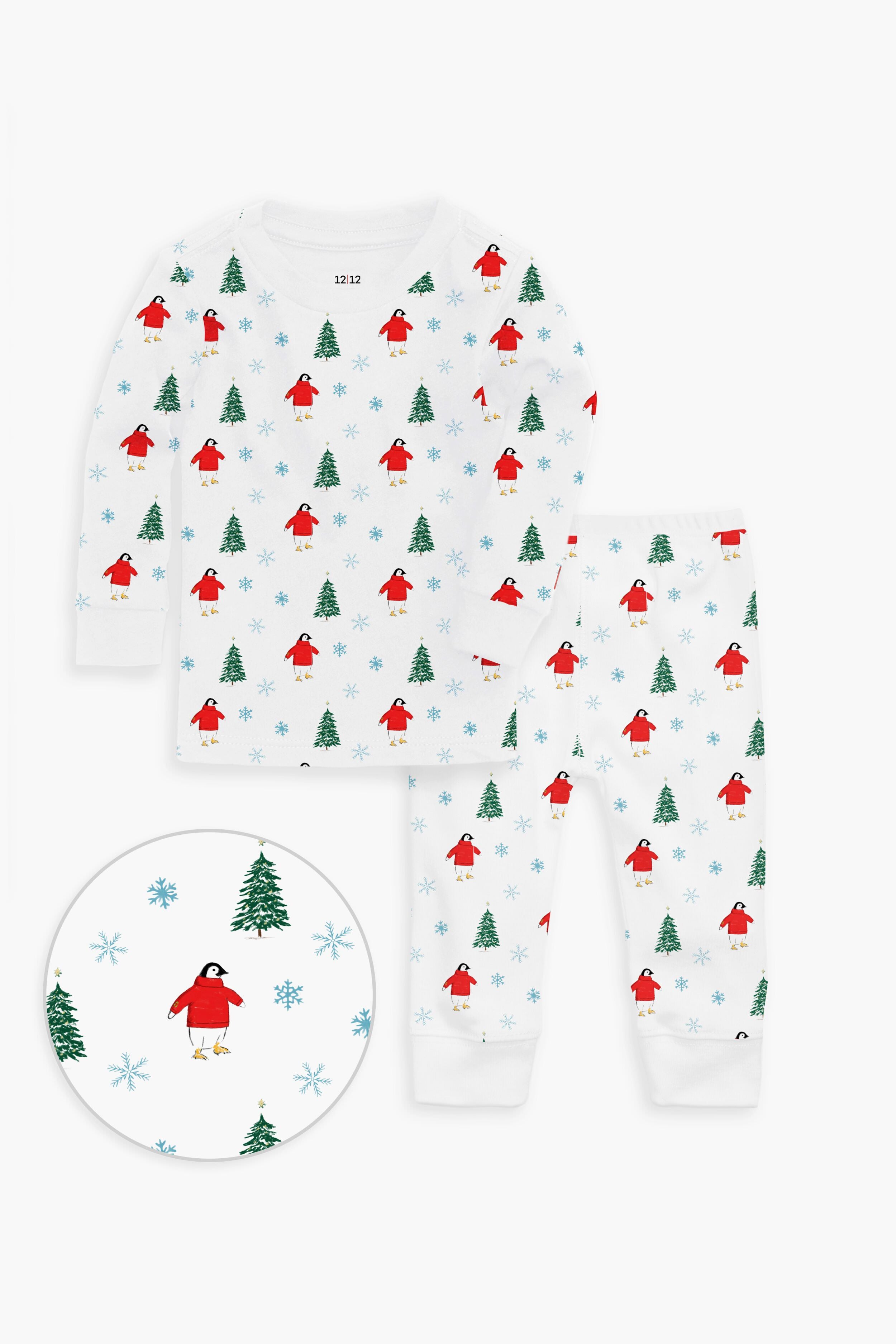 12|12 children’s white cotton pajama set with a festive print of red birds, green trees, and blue snowflakes. OEKO-TEX certified for toddler comfort; close-up highlights the charming details.