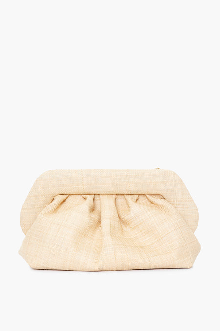 A beige, textured natural raffia clutch purse by Themoire features a structured frame, gathered fabric design, and is elegantly crafted in Italy.