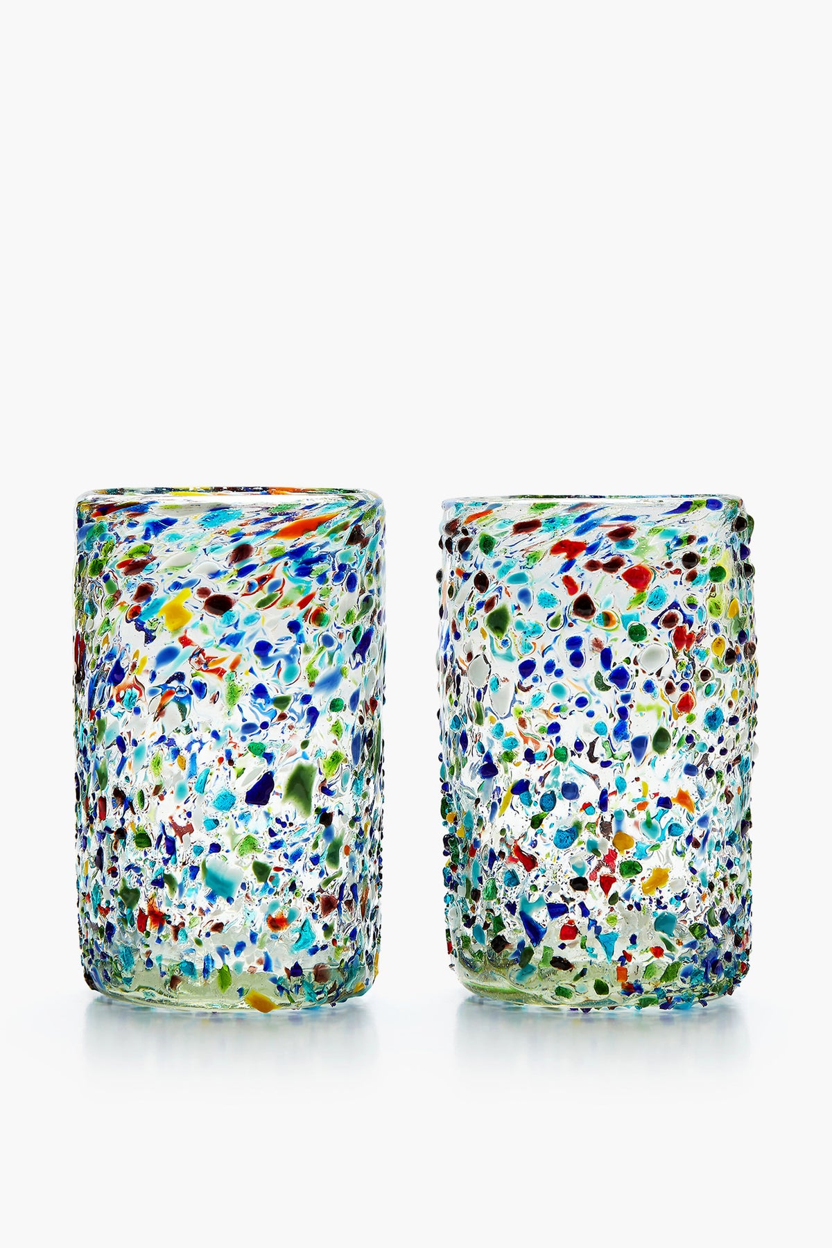 Two hand-blown Chefanie Confetti Glasses, featuring a textured surface with multicolored speckles in blue, green, red, and yellow, sit side by side—ideal for a cheerful housewarming gift.