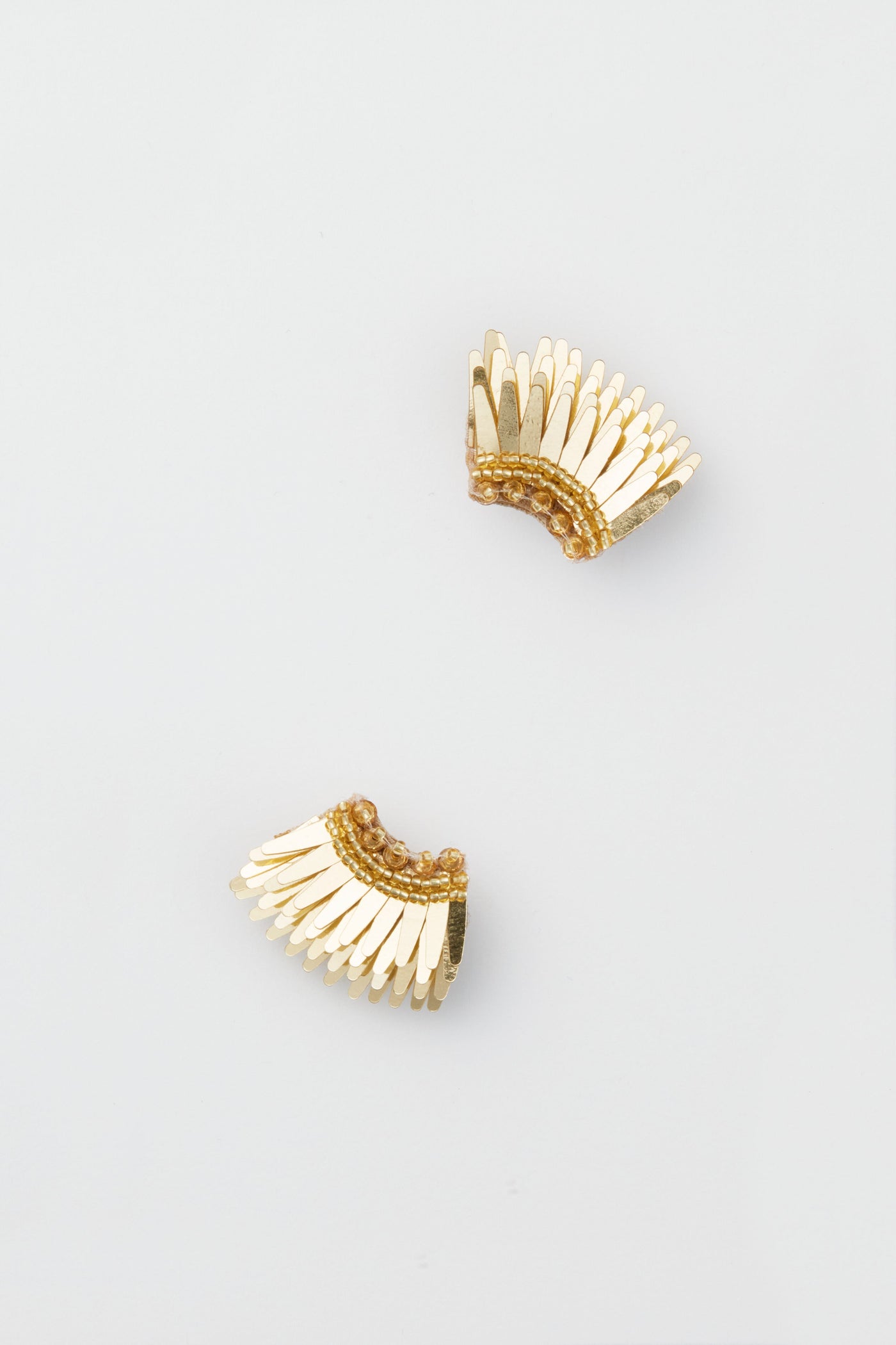 Mignonne Gavigan Gold Micro Madeline Earrings feature a gold-tone, fan-shaped design with layered, textured details.