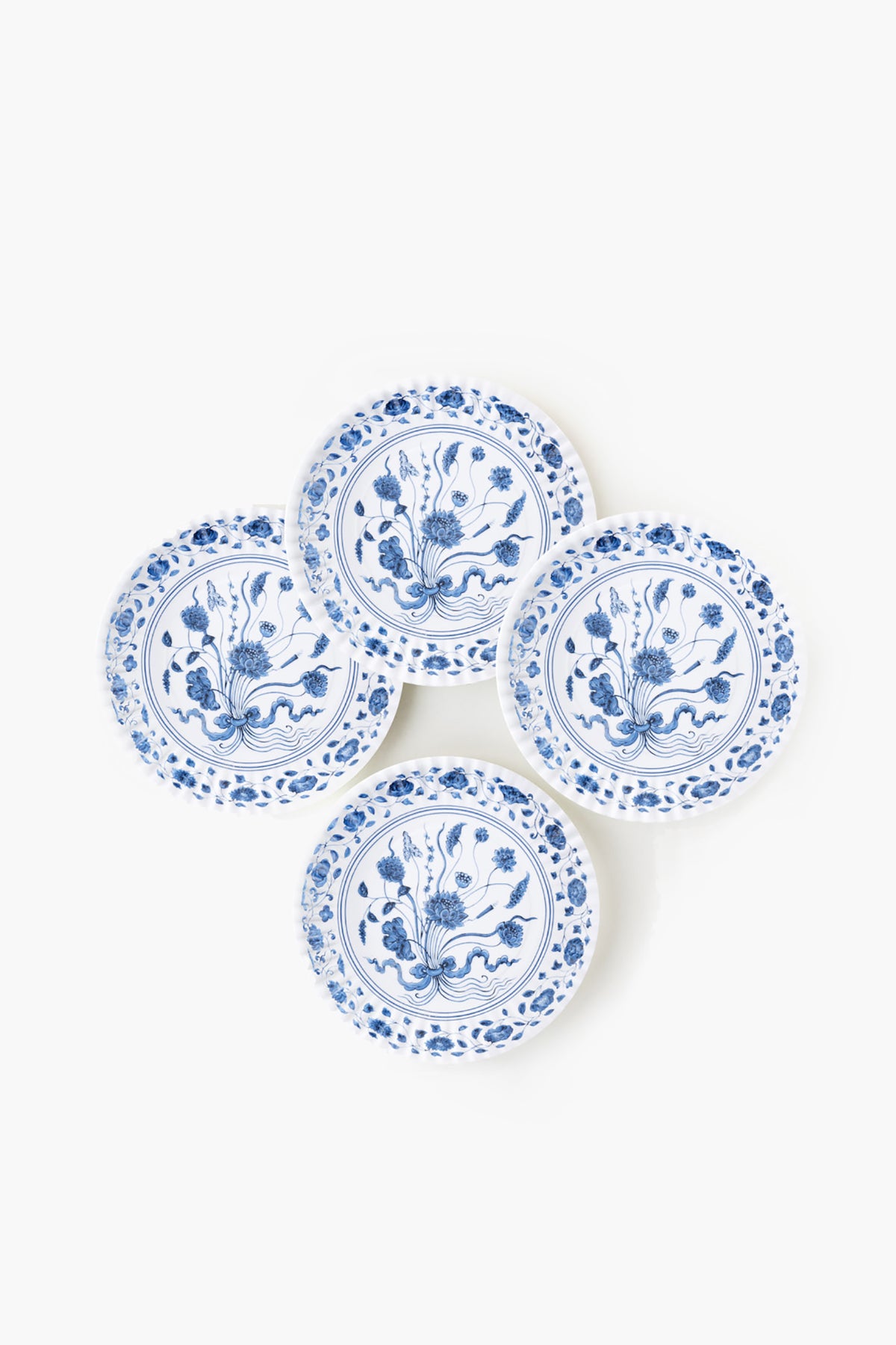 Four round white botanical plates by One Hundred 80 Degrees feature blue floral patterns and are arranged in a slightly overlapping cluster. Made from melamine, these plates combine style with dishwasher-safe convenience.