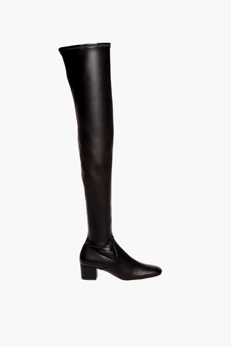 A single STAUD black over-the-knee vegan leather boot with a low block heel and rounded toe is displayed.