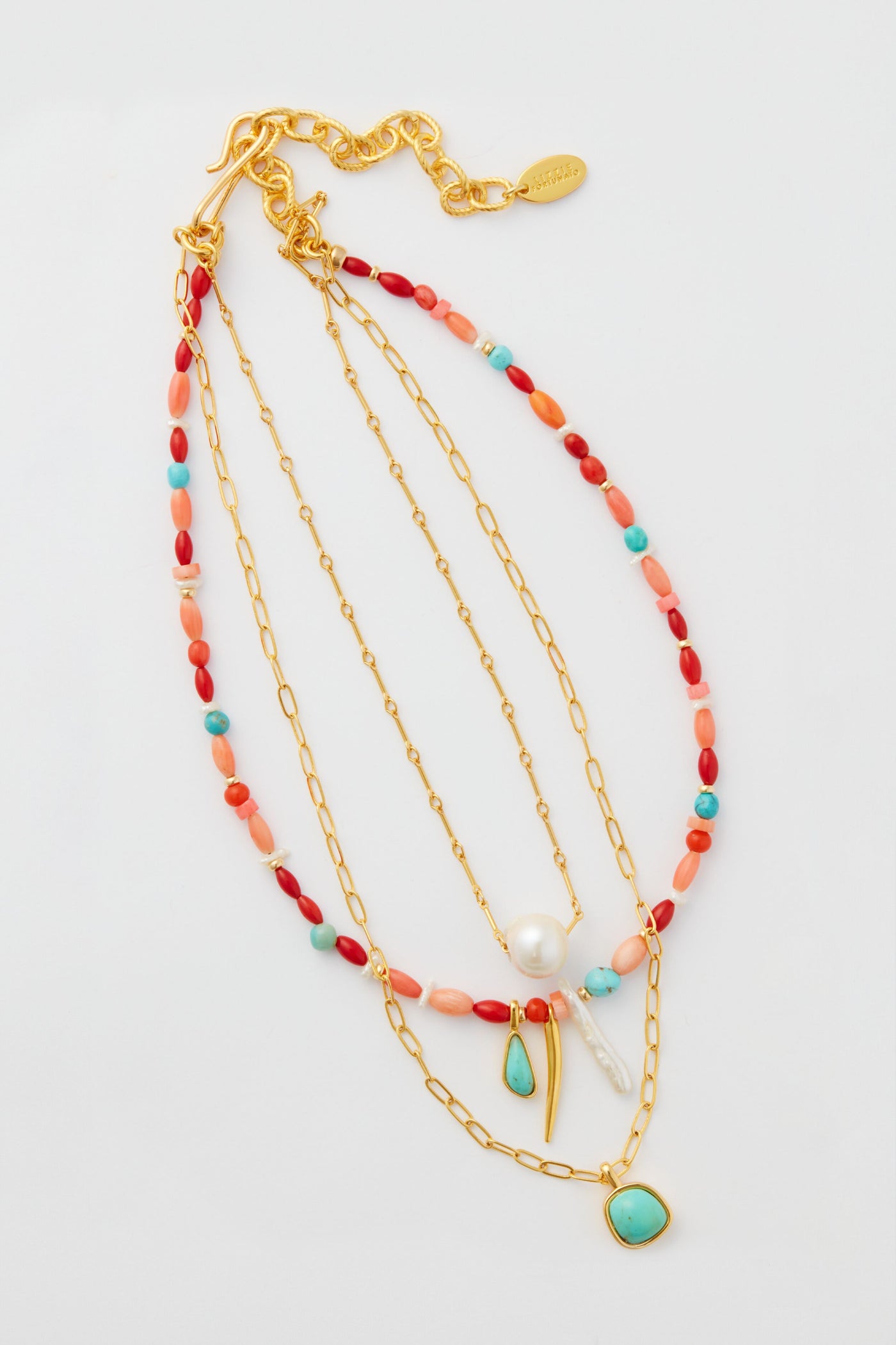Three gold-plated chain necklaces by Lizzie Fortunato, adorned with colorful beads, pearls, and turquoise pendants, create a chic multi-strand necklace look.