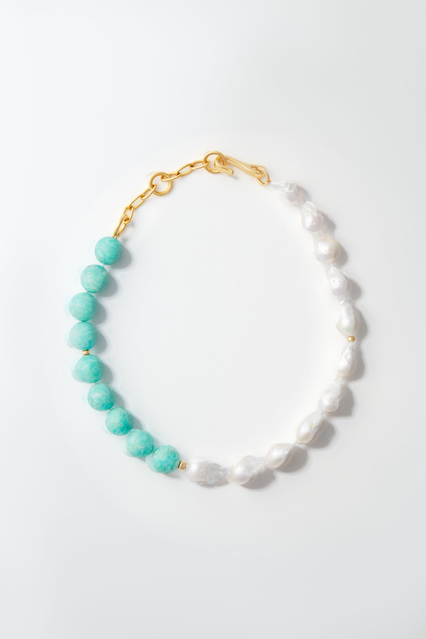 The Lizzie Fortunato bracelet with alternating round turquoise beads and irregular white pearls, finished with a gold chain clasp, pairs beautifully with a freshwater pearl necklace.