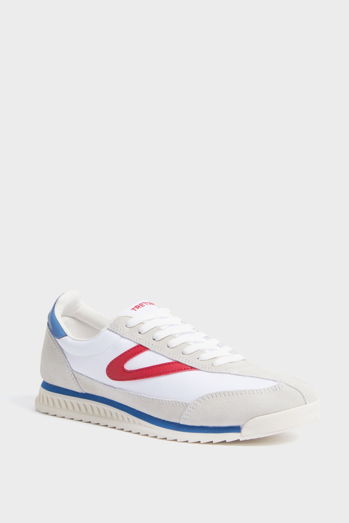 A Tretorn women's Rawlins sneaker in white features beige suede details, a red side accent, blue heel trim, white laces, and a textured rubber sole.