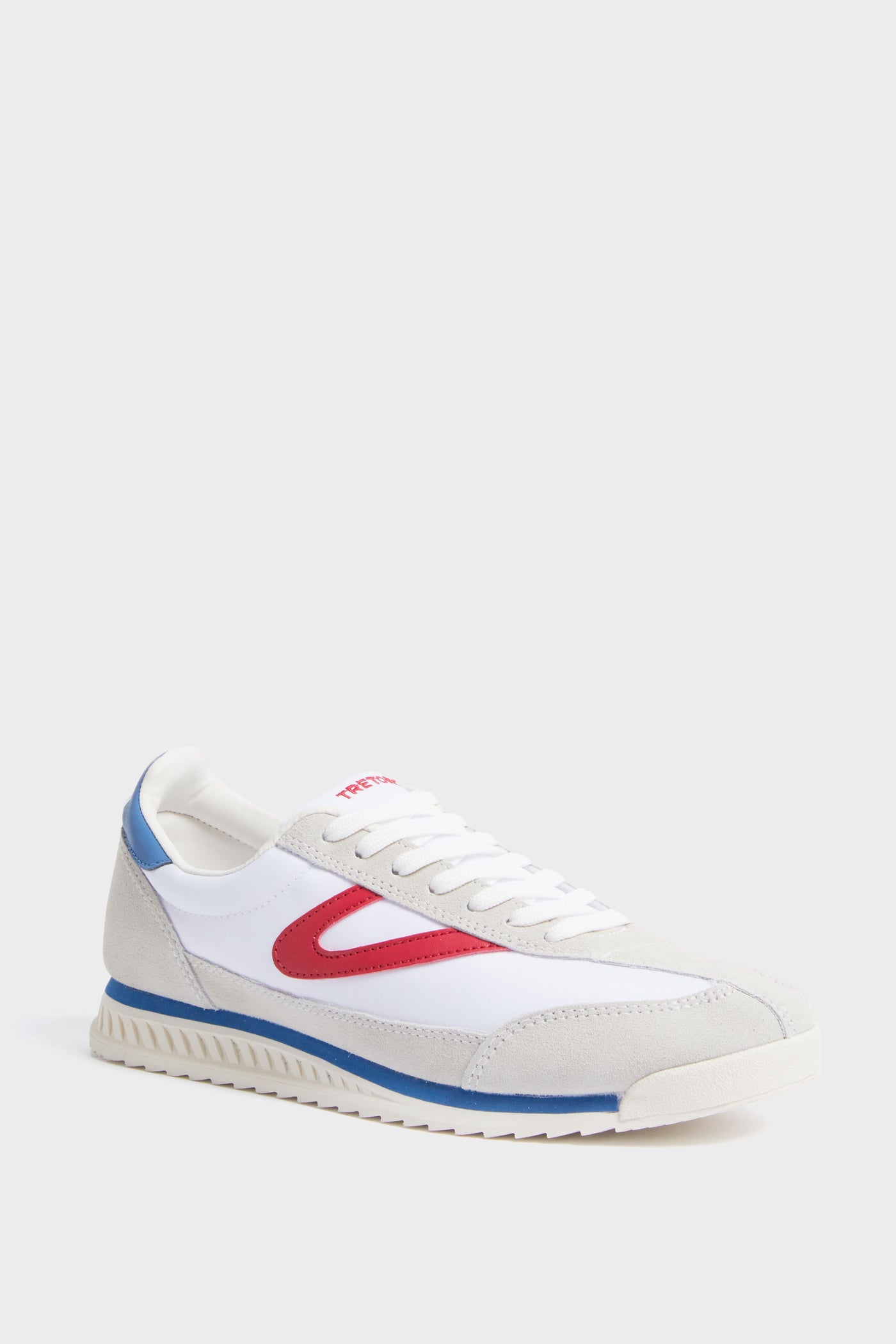 A Tretorn women's Rawlins sneaker in white features beige suede details, a red side accent, blue heel trim, white laces, and a textured rubber sole.