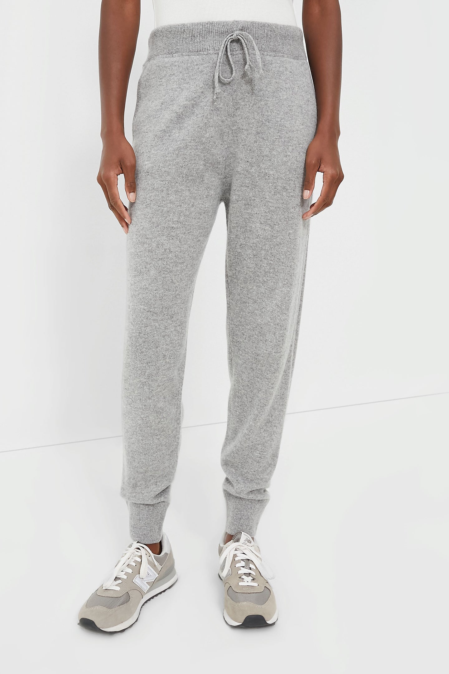 Wearing light gray RLX Ralph Lauren cashmere jogger sweatpants and gray sneakers, this person exudes a relaxed golf-inspired vibe.