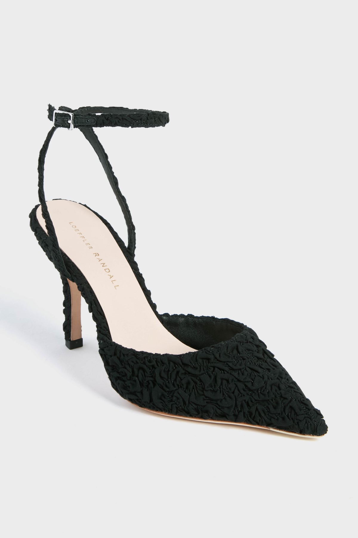 A black pointed-toe high heel from Loeffler Randall with an adjustable ankle strap and textured fabric, featuring the elegant Black Puckered Jaden Heels.