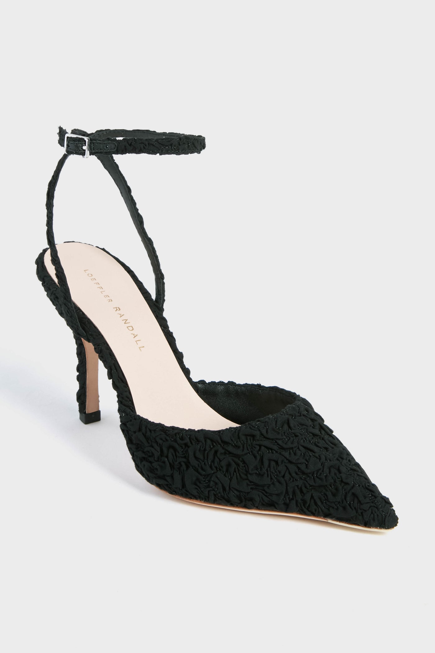 A black pointed-toe high heel from Loeffler Randall with an adjustable ankle strap and textured fabric, featuring the elegant Black Puckered Jaden Heels.