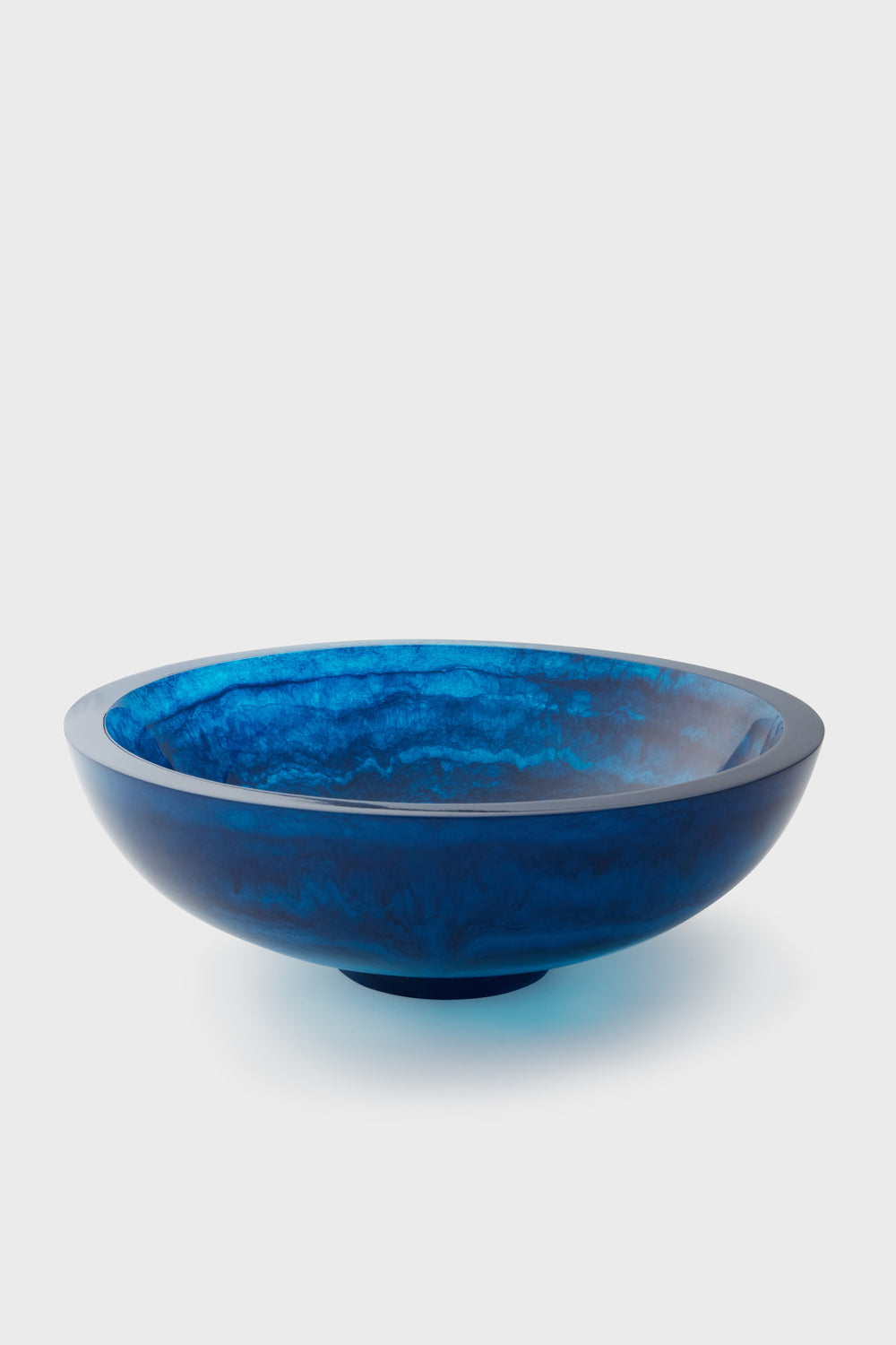 The Lily Juliet shallow round blue glass bowl features a handmade, smooth, and glossy surface—perfect as a food-safe decorative dish.