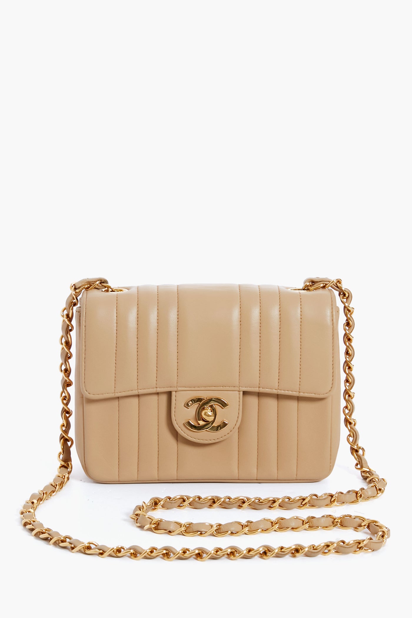 A beige quilted leather Tuckernuck Archive Collection bag with a gold chain strap and turn-lock closure, featuring classic elegance.