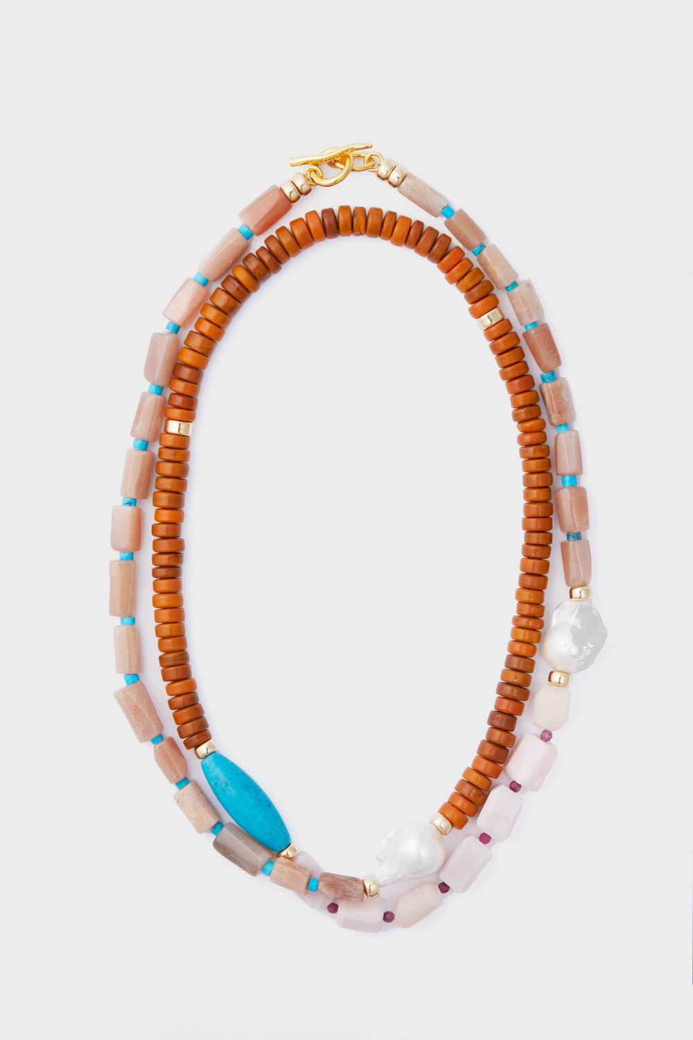 The Lizzie Fortunato beaded necklace features two strands of brown, pink, blue, white, and gold beads—some made from recycled glass—finished with a gold clasp.