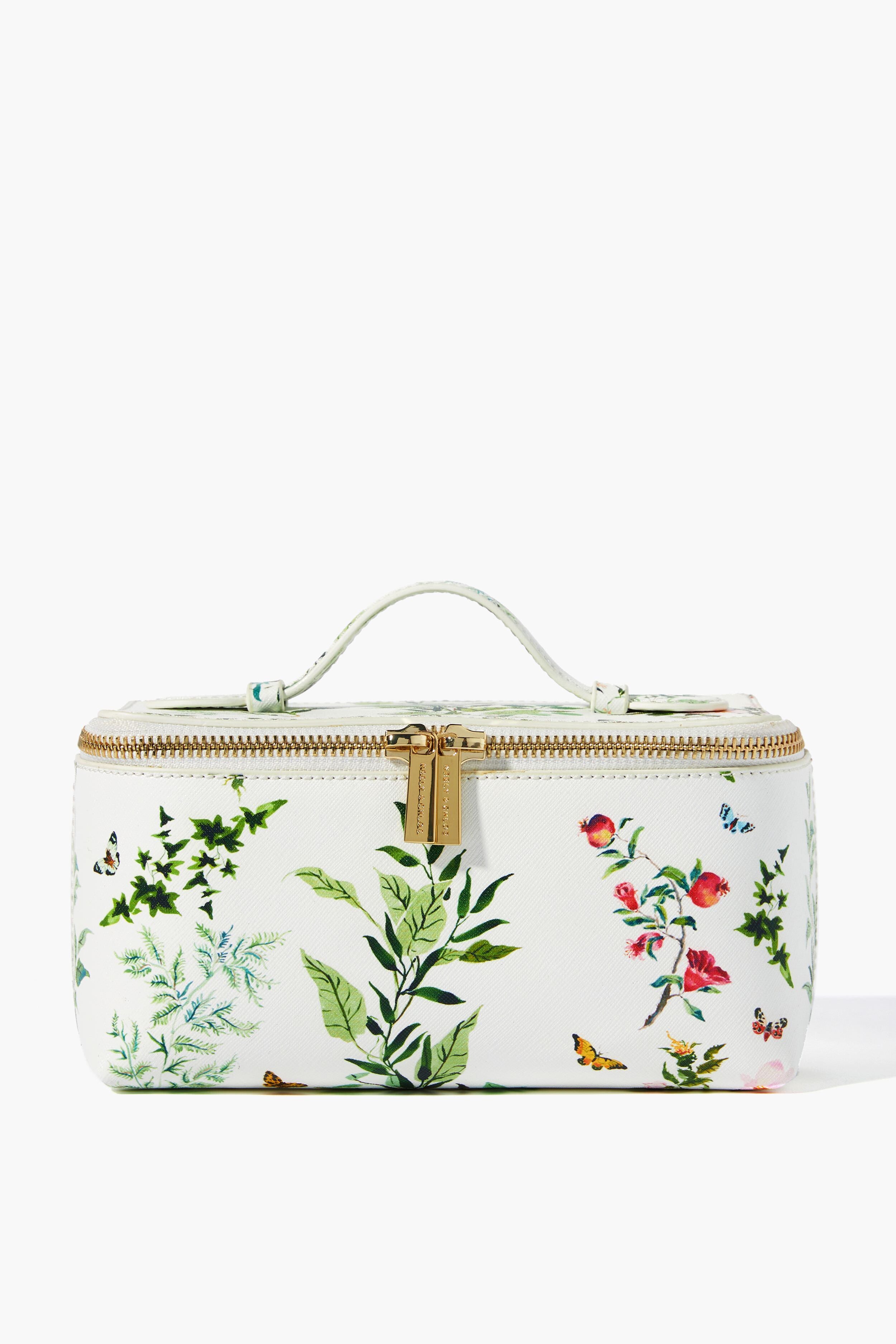 The Neely & Chloe x Inslee white rectangular small vanity case, crafted from saffiano leather with a gold zipper and handle, showcases colorful botanical and insect illustrations—an ideal holiday gift.
