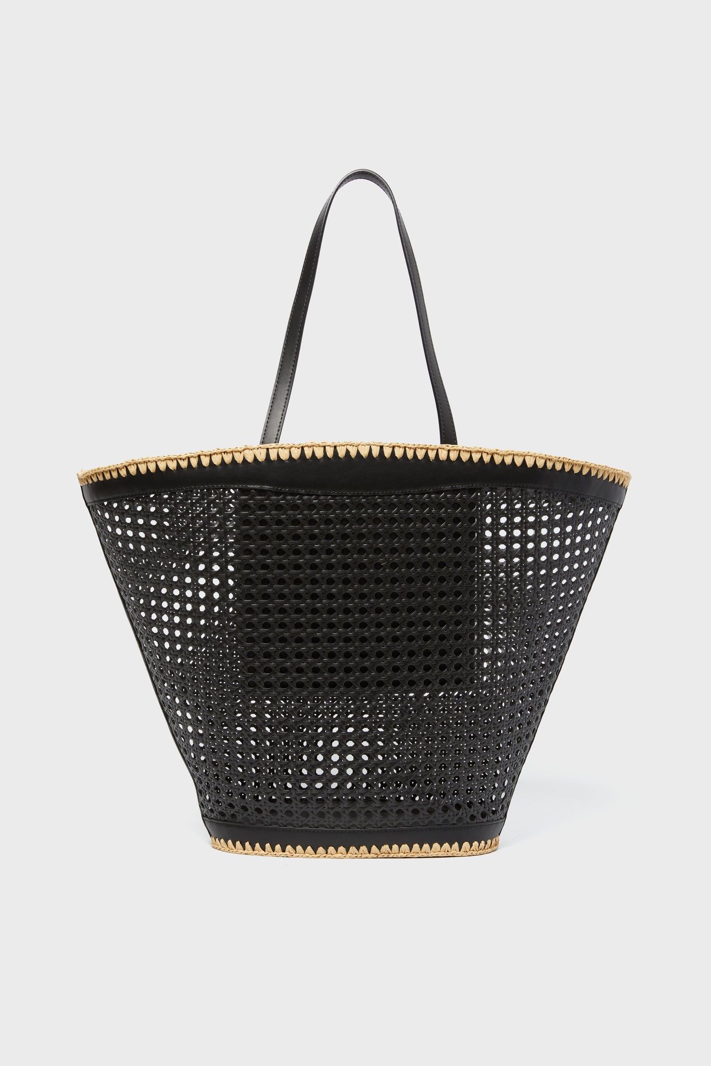 A black perforated BTB Ellie Tote with two handles and tan trim at the top and bottom—perfect for adding a boho-chic accent to any outfit.