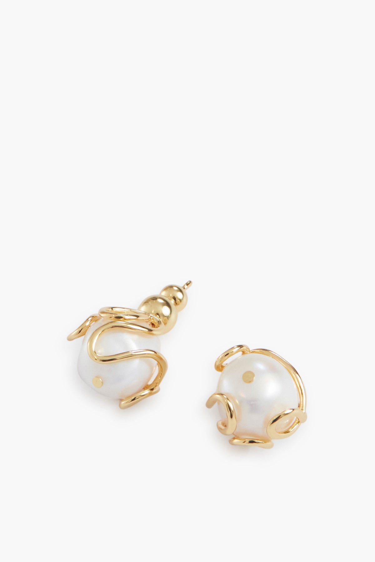 Cult Gaia gold-tone earrings featuring large Baroque pearls encased in an abstract gold wire trim design.