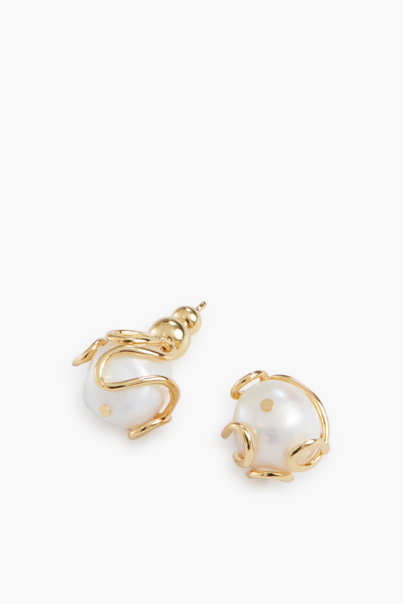 Cult Gaia gold-tone earrings featuring large Baroque pearls encased in an abstract gold wire trim design.