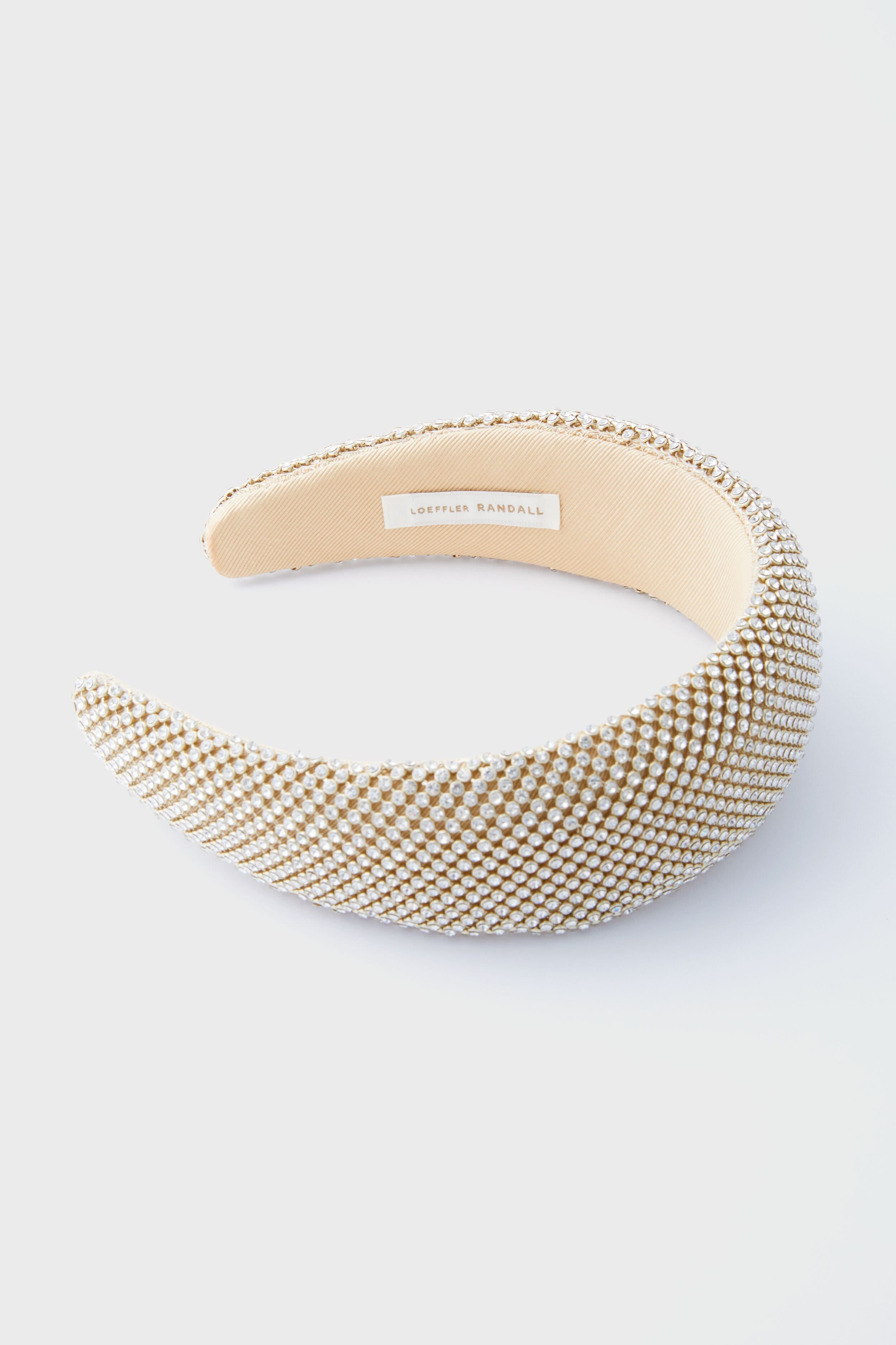 A Loeffler Randall puffy headband, padded and adorned with small white and gold beads, features inner labeling and exemplifies elegant Gold Diamante style.