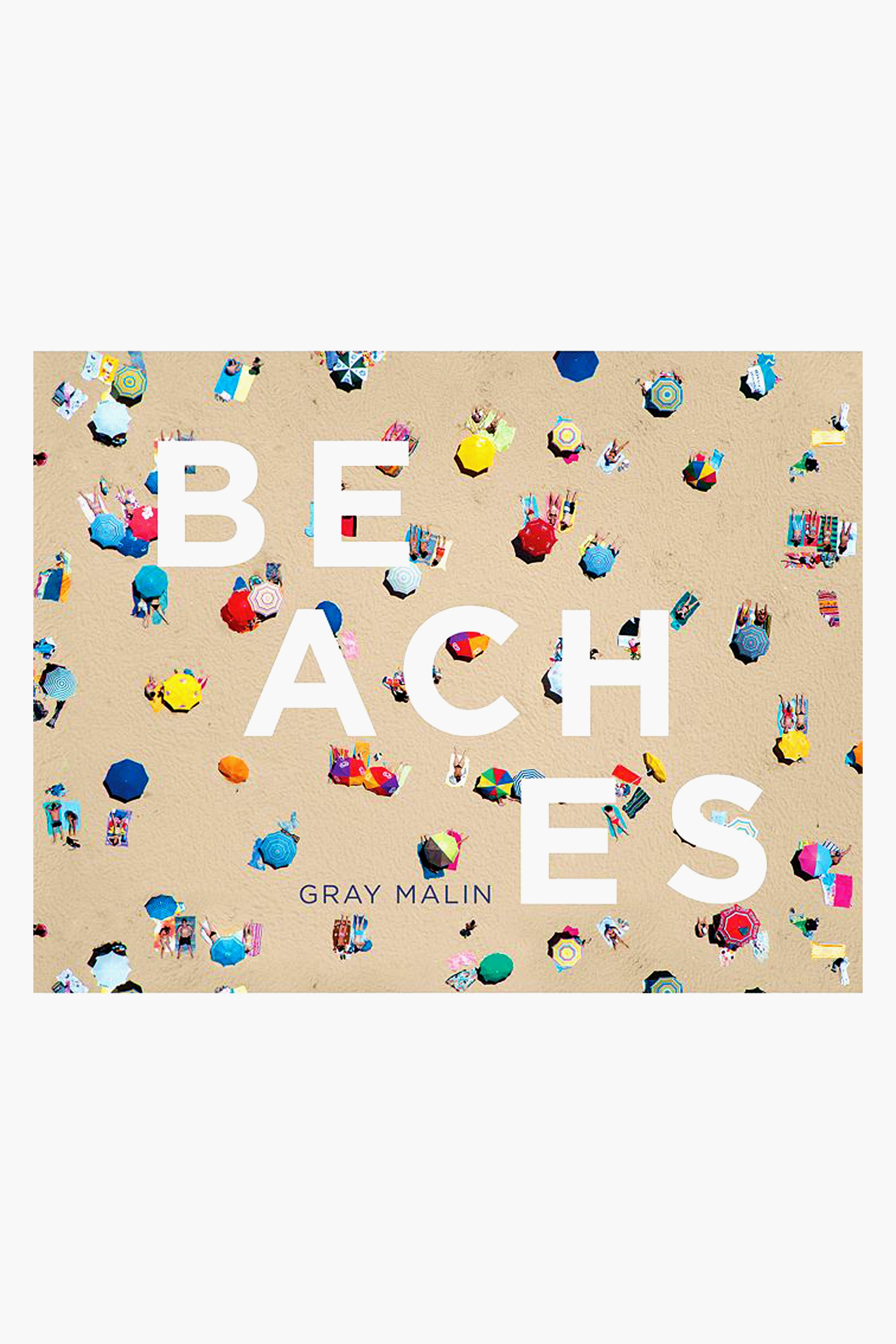 Aerial view of a crowded sandy beach with colorful umbrellas and towels, overlaid with large white text reading BEACHES and Gray Malin's name below—an eye-catching Rizzoli coffee table book featuring stunning aerial beach photography.
