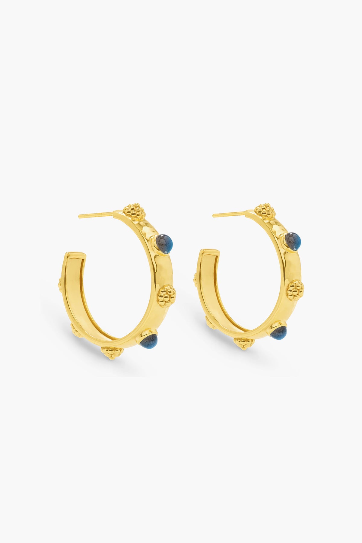 A pair of Cleopatra Oval Hoops by Capucine De Wulf, crafted in 18K gold-plated metal with textured details and small blue labradorite gemstone accents.