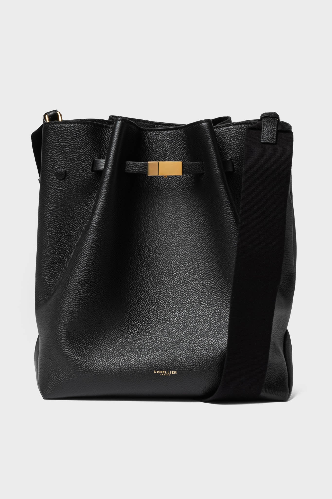 A black leather hobo bag by Demellier, featuring a wide shoulder strap, gold-tone hardware, and discreet branding near the bottom—an elegant addition to any collection of handcrafted handbags.