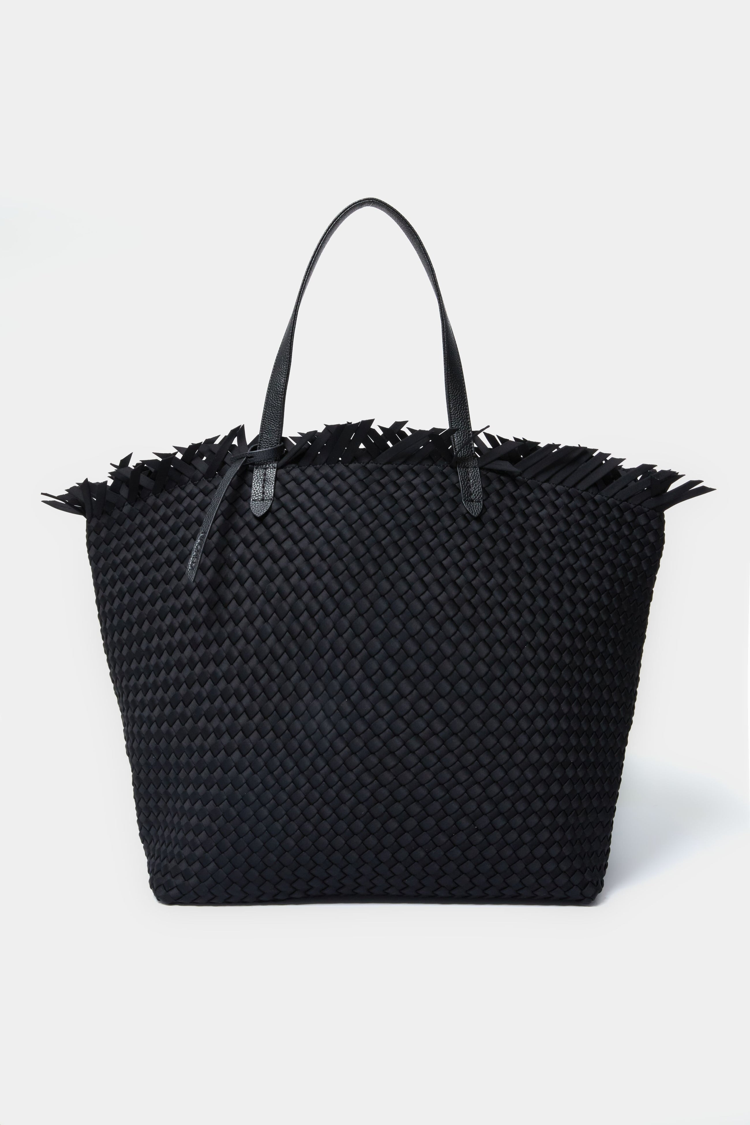 A large black handwoven neoprene tote bag by Naghedi, featuring vegan leather handles and fringe detailing along the top edge.