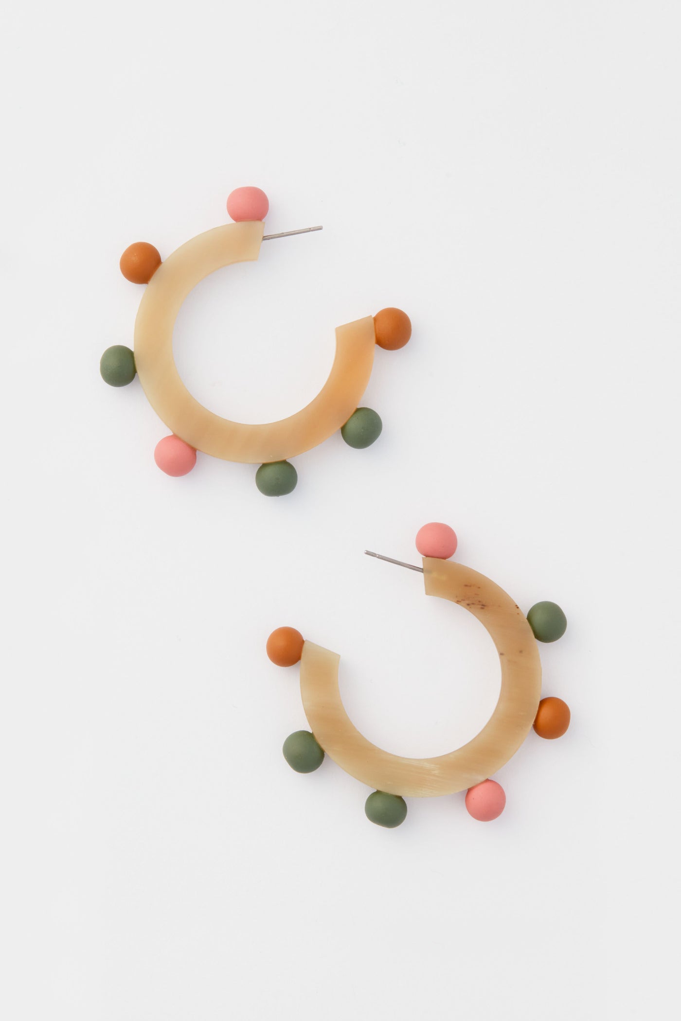 Sunshine Tienda’s lightweight, hand-painted semi-circular hoop earrings feature tan bases and three colorful round beads—pink, green, and orange—adding a vibrant touch to any look.