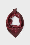 A maroon silk scarf by Tuckernuck Accessories, featuring a small mulberry floral print and folded in a triangular shape, crafted from 100% silk.