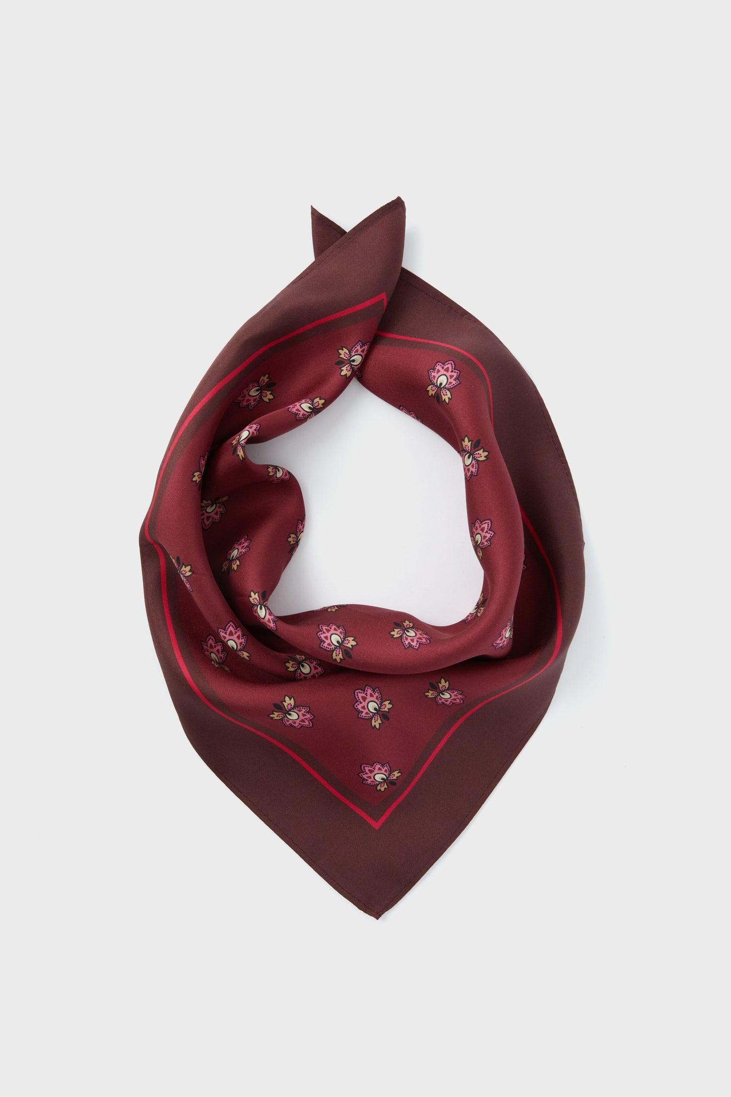 A maroon silk scarf by Tuckernuck Accessories, featuring a small mulberry floral print and folded in a triangular shape, crafted from 100% silk.