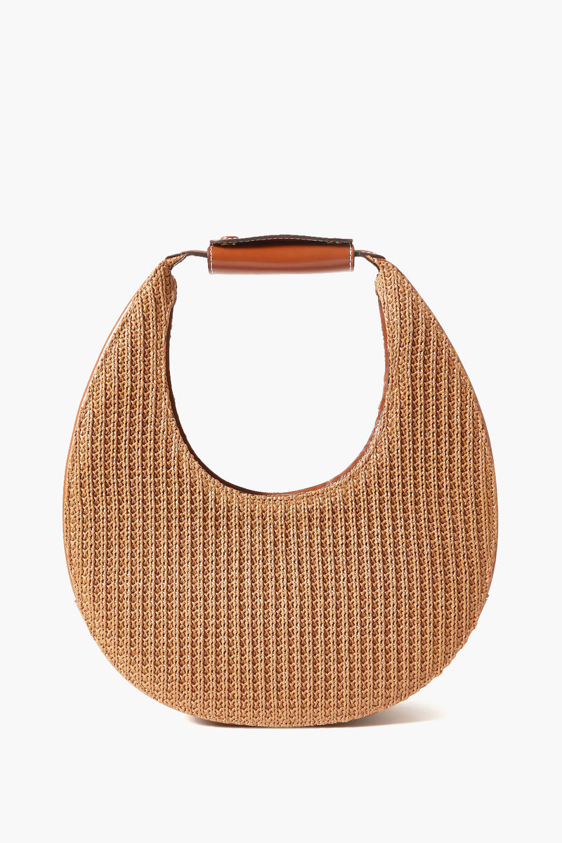 STAUD's structured shoulder bag features a woven crescent shape in leather and raffia with a leather-wrapped handle.