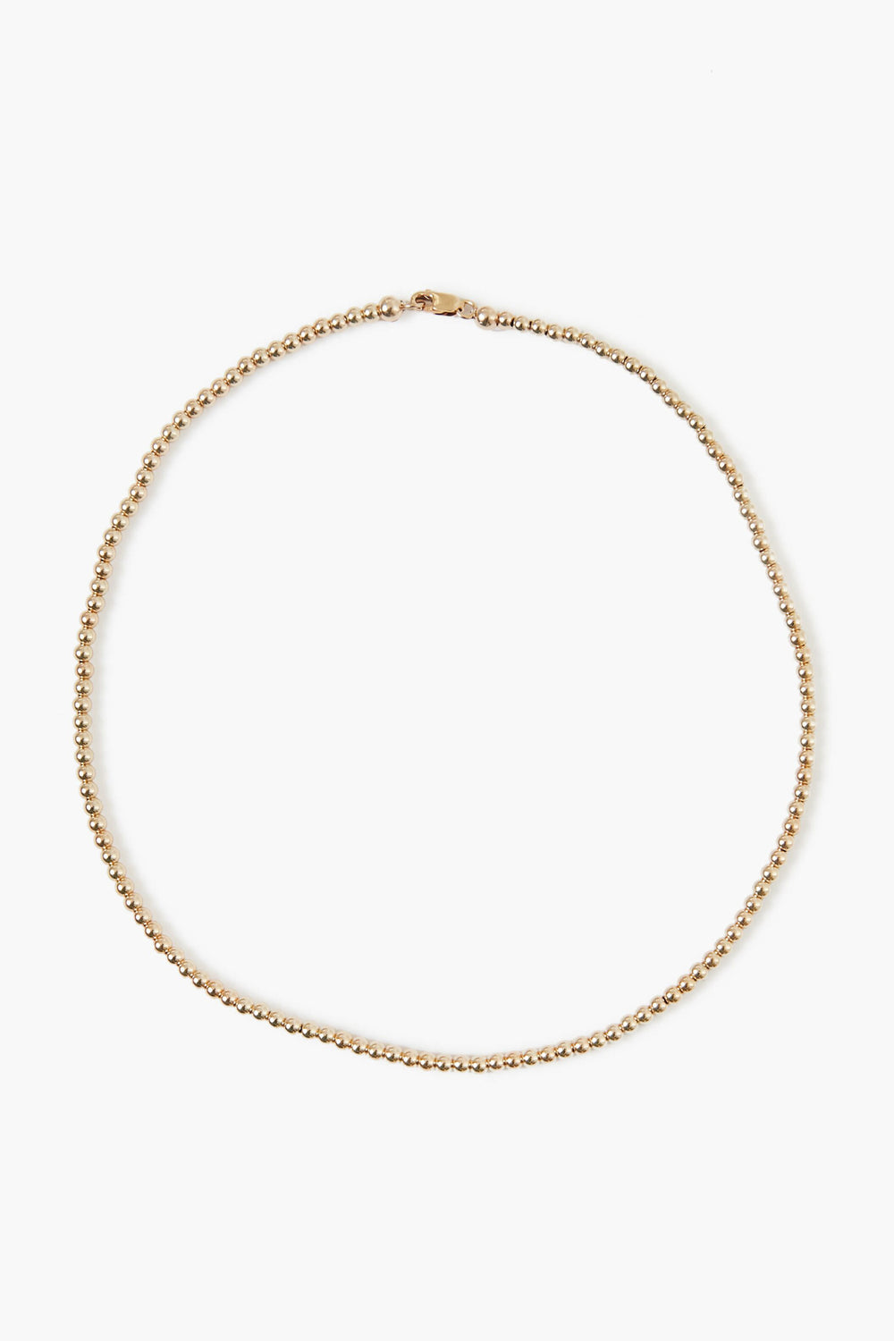 A delicate Alexa Leigh 14k gold plated beaded necklace with a small clasp, arranged in a circular shape—perfect for layering or wearing solo as a gold ball necklace.