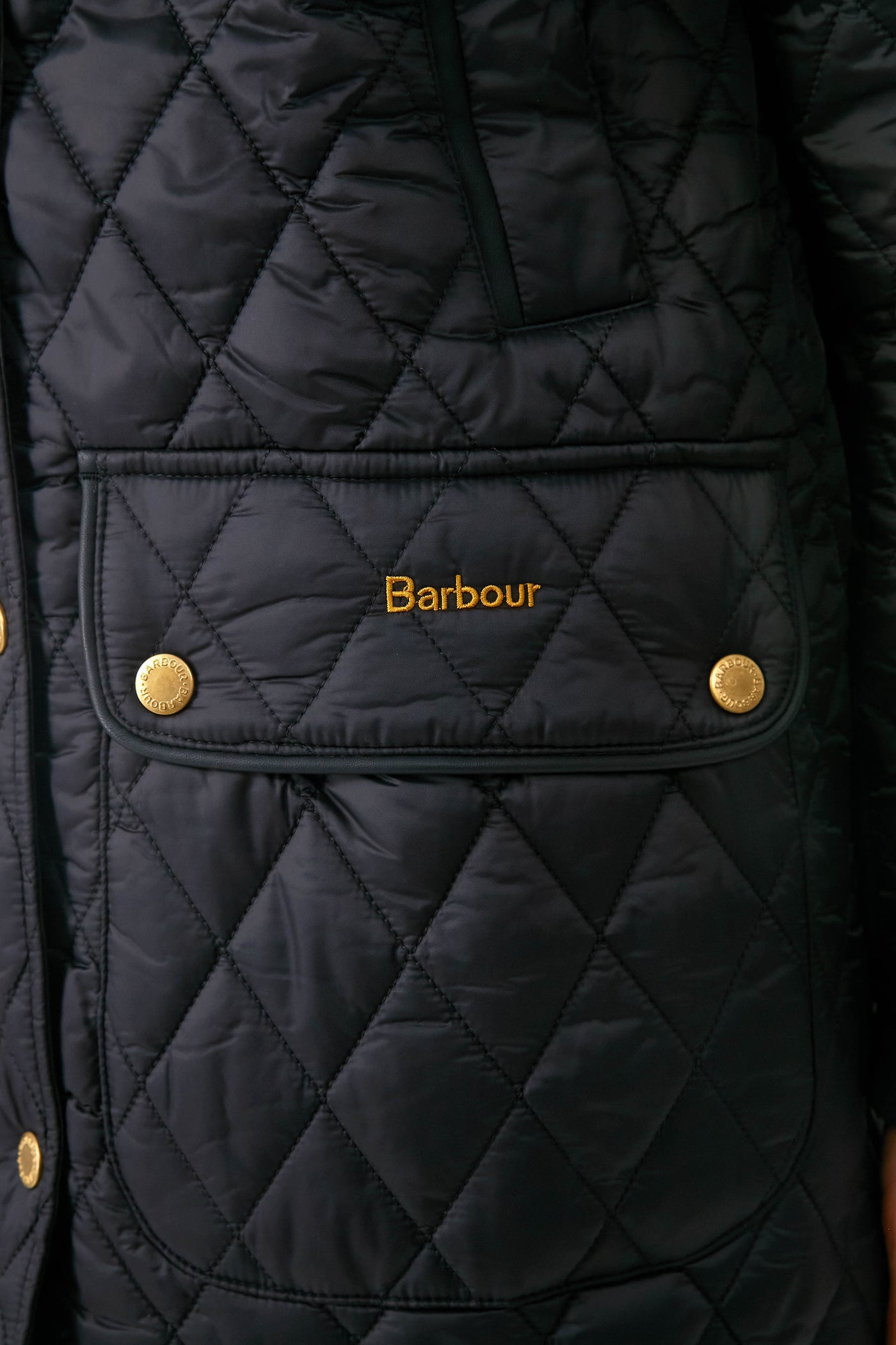 Black Kilmarie Quilt: A classic, high-end diamond-quilted jacket with gold-tone snap buttons, embroidered logo, and leather detailing, exuding effortless style and fun sophistication.