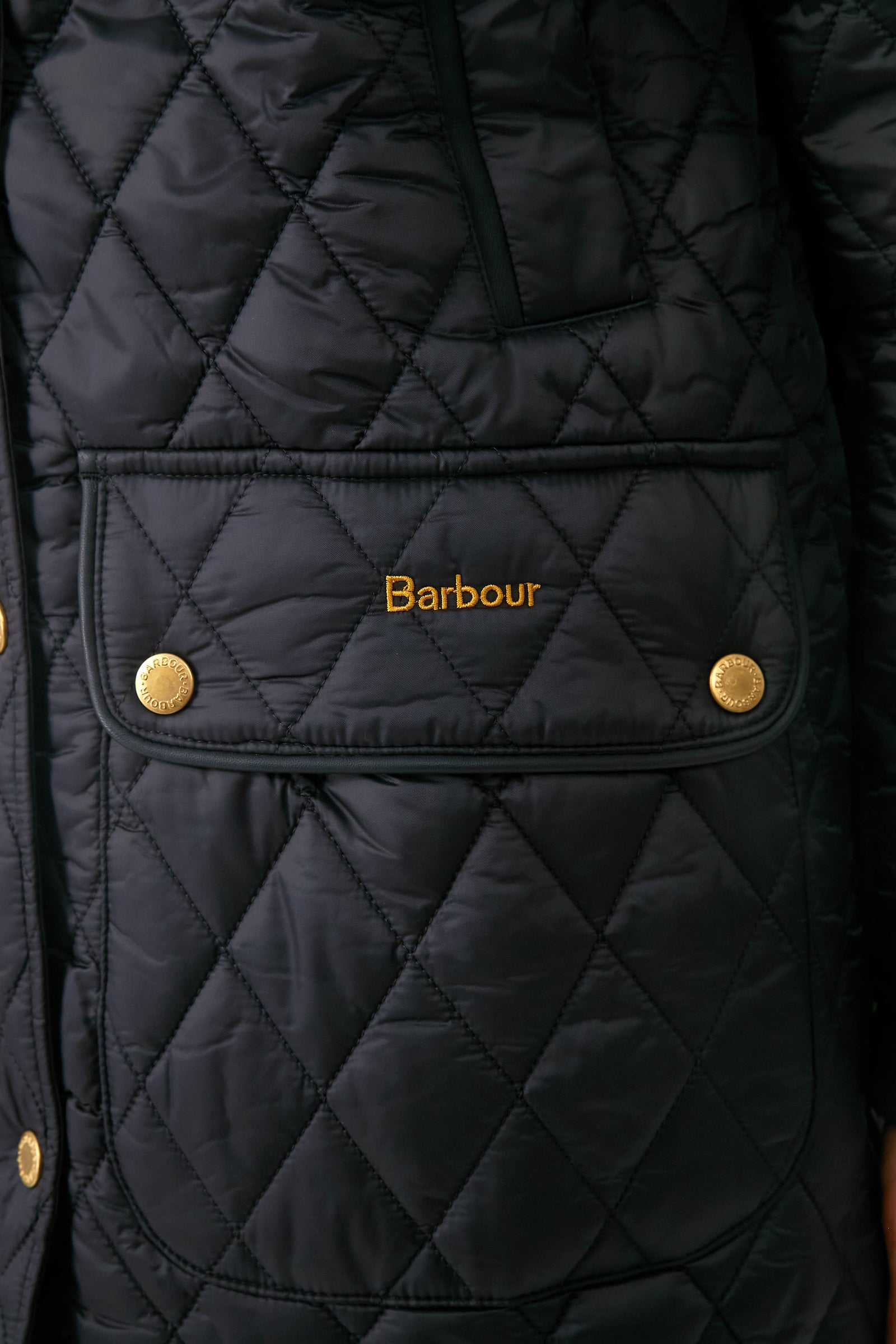 Black Kilmarie Quilt: A classic, high-end diamond-quilted jacket with gold-tone snap buttons, embroidered logo, and leather detailing, exuding effortless style and fun sophistication.