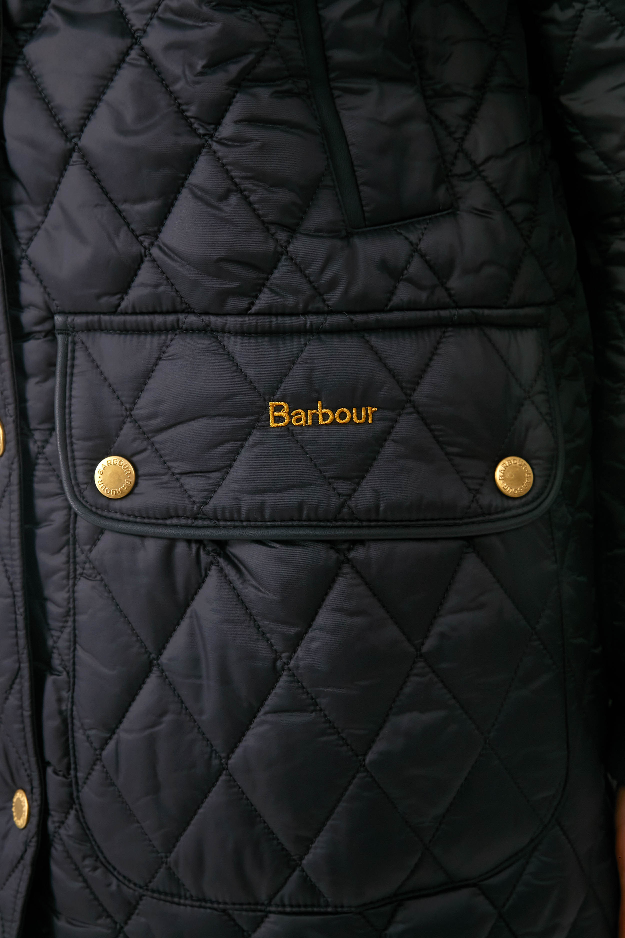 Black Kilmarie Quilt: A classic, high-end diamond-quilted jacket with gold-tone snap buttons, embroidered logo, and leather detailing, exuding effortless style and fun sophistication.