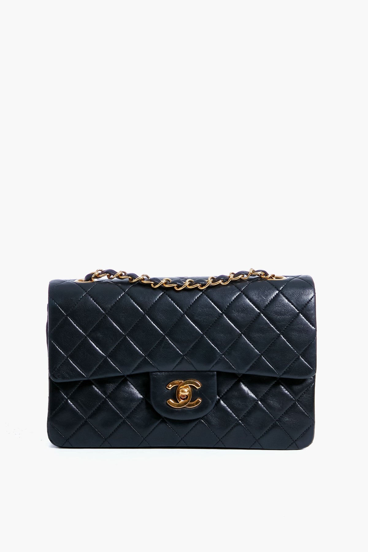 A Tuckernuck Archive Collection Classic Flap Bag in black quilted leather features a gold chain strap and a gold interlocking CC clasp on the front flap.