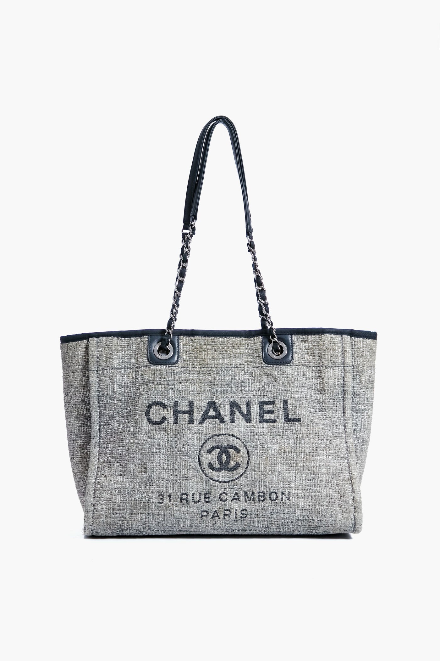 A Tuckernuck Archive Collection Grey Deauville Tote with black chain handles and front print, capturing the chic spirit of Tuckernuck’s ready-to-wear style.