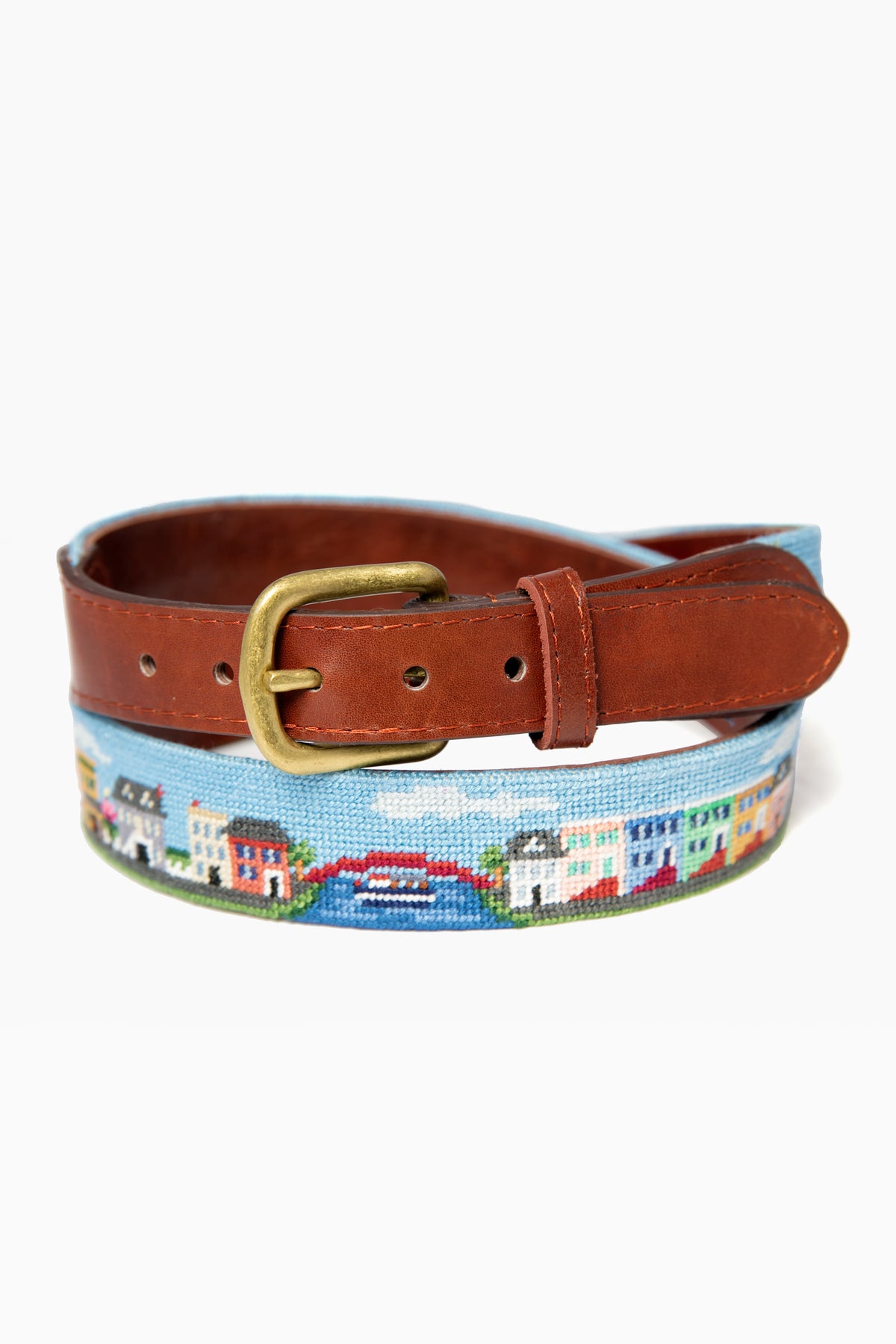 A Smathers and Branson leather belt with a brass buckle, showcasing a colorful hand-stitched houses and bridge design.