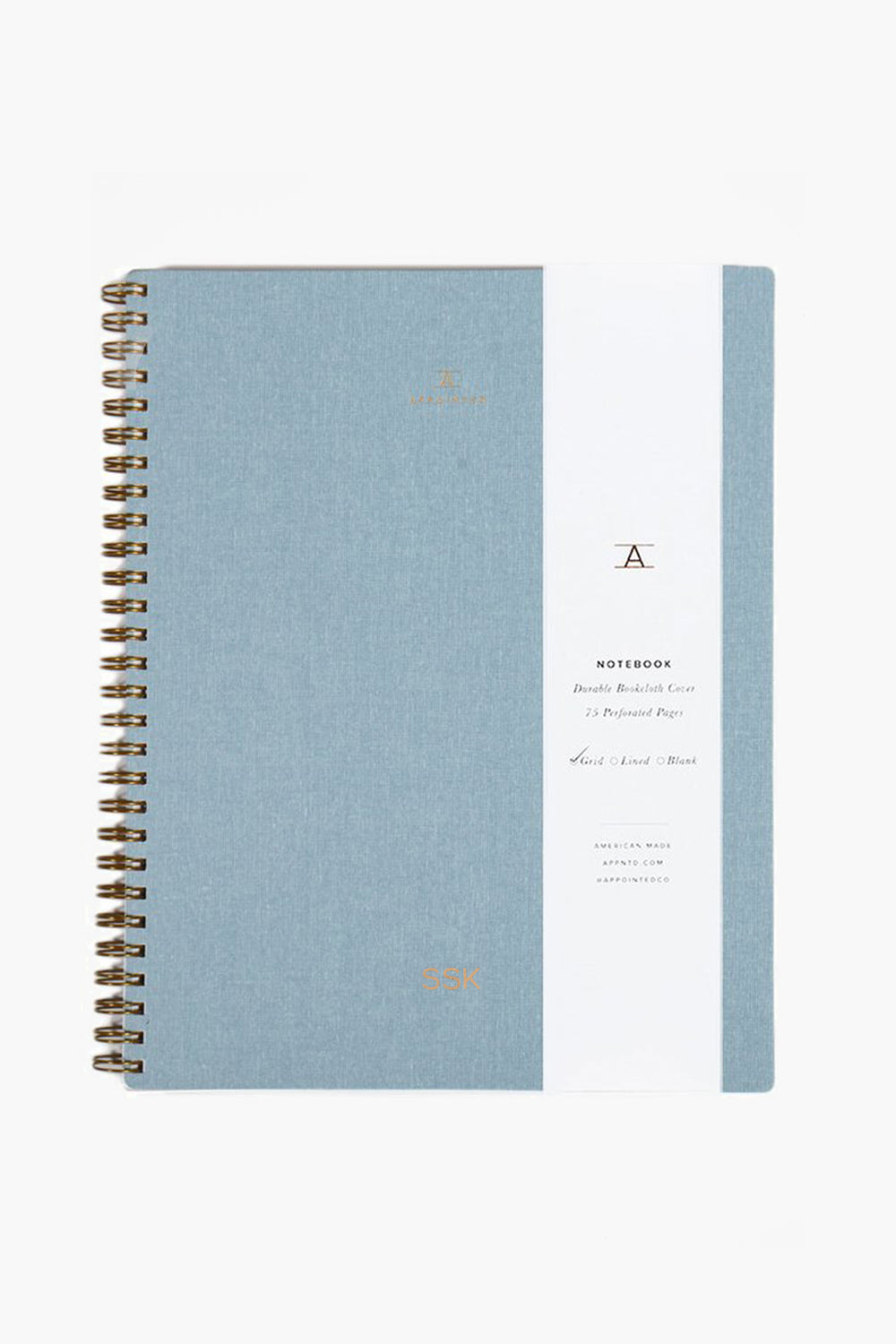 The APPOINTED Chambray Blue Lined Notebook features a spiral binding, white vertical label with gold text and accents, a durable book-cloth cover, and recycled paper.