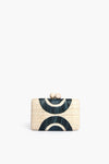 The Kayu rectangular straw clutch features a geometric dark blue and cream pattern and a clasp closure with two round beige knobs. This stylish accessory is part of our sustainable collection.