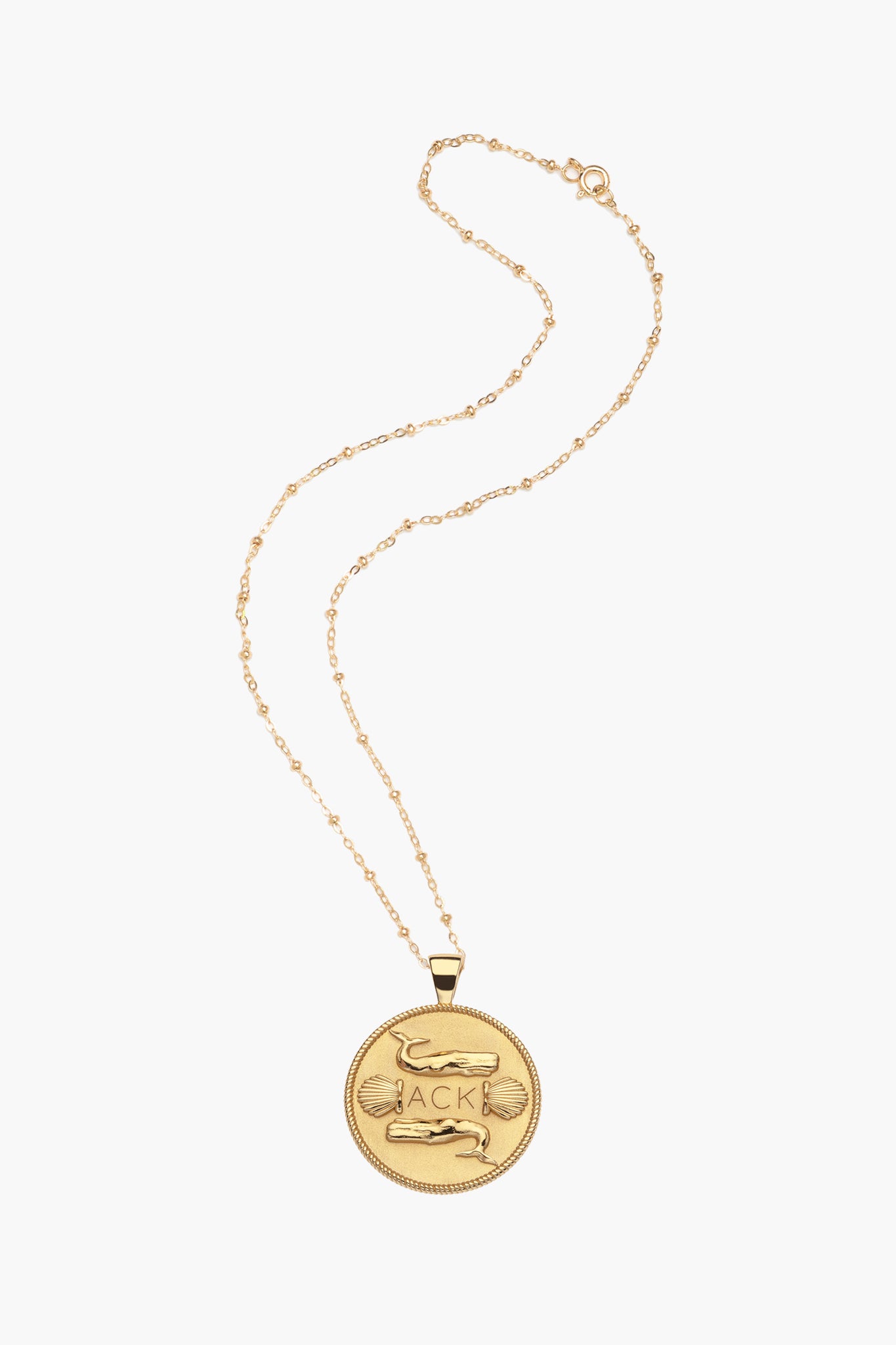 A round engraved ACK charm gold coin pendant necklace by Jane Win, featuring decorative details and crafted in 14k gold plated sterling silver.