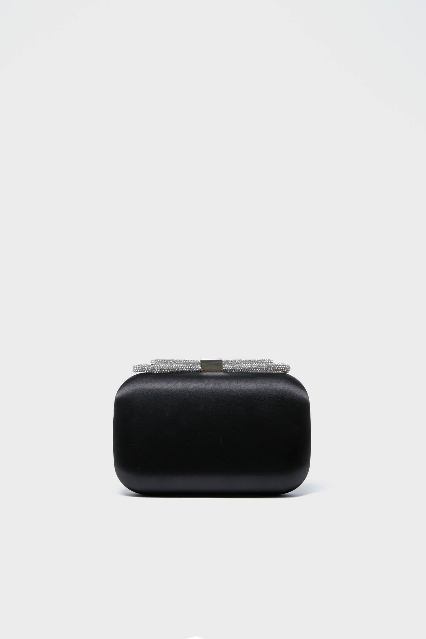 The Olga Berg Black Ada Crystal Bow Clutch is a rectangular black evening bag with a crystal-embellished, silver-toned clasp—combining sophistication and elegance for any occasion.