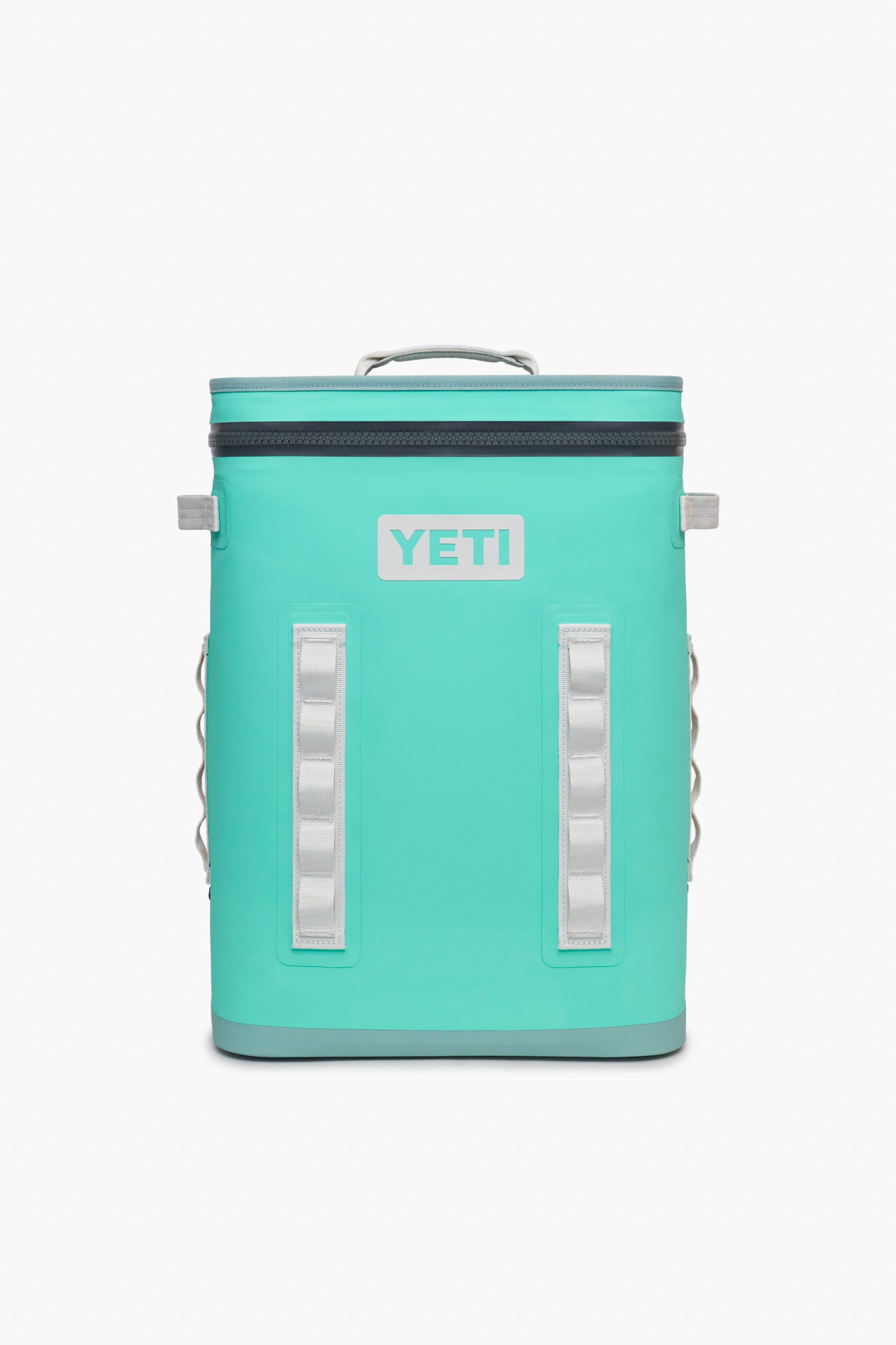 A YETI Hopper BackFlip 24 backpack cooler in teal with a zippered top, sturdy handle, and white accents is shown. This leakproof cooler is ideal for carrying drinks wherever you go.