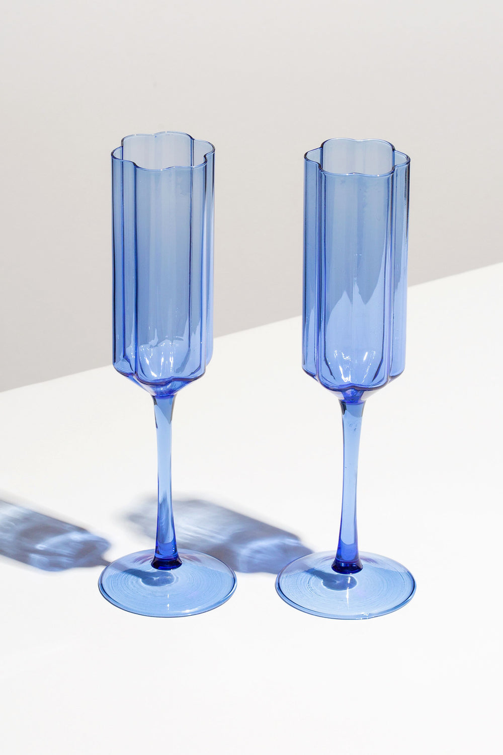 Two FAZEEK Blue Wave Flutes, crafted from borosilicate glass, stand side by side on a white surface with soft shadows behind them.